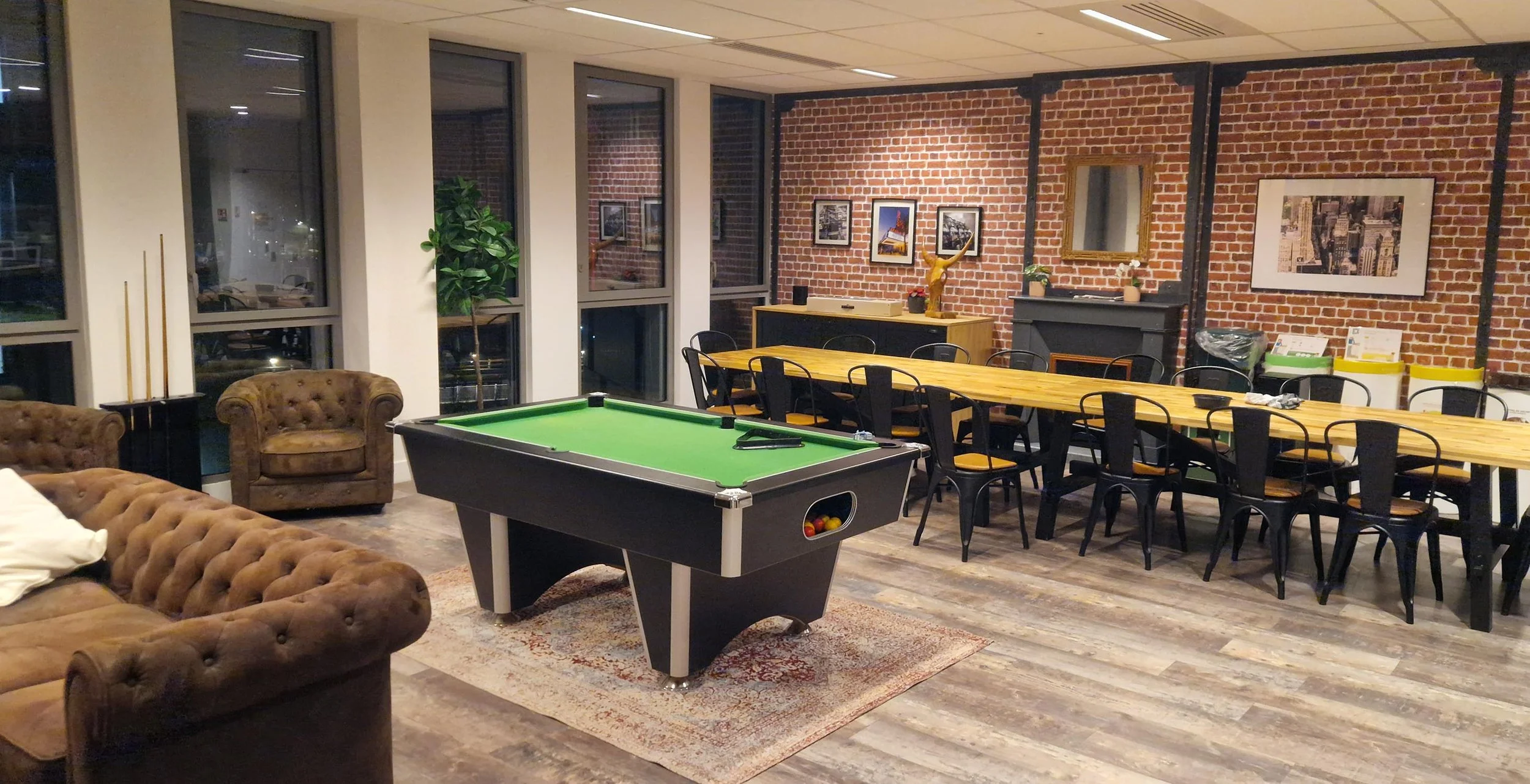 Salle de pause d'une entreprise avec un billard dans une ambiance chaleureuse et conviviale.