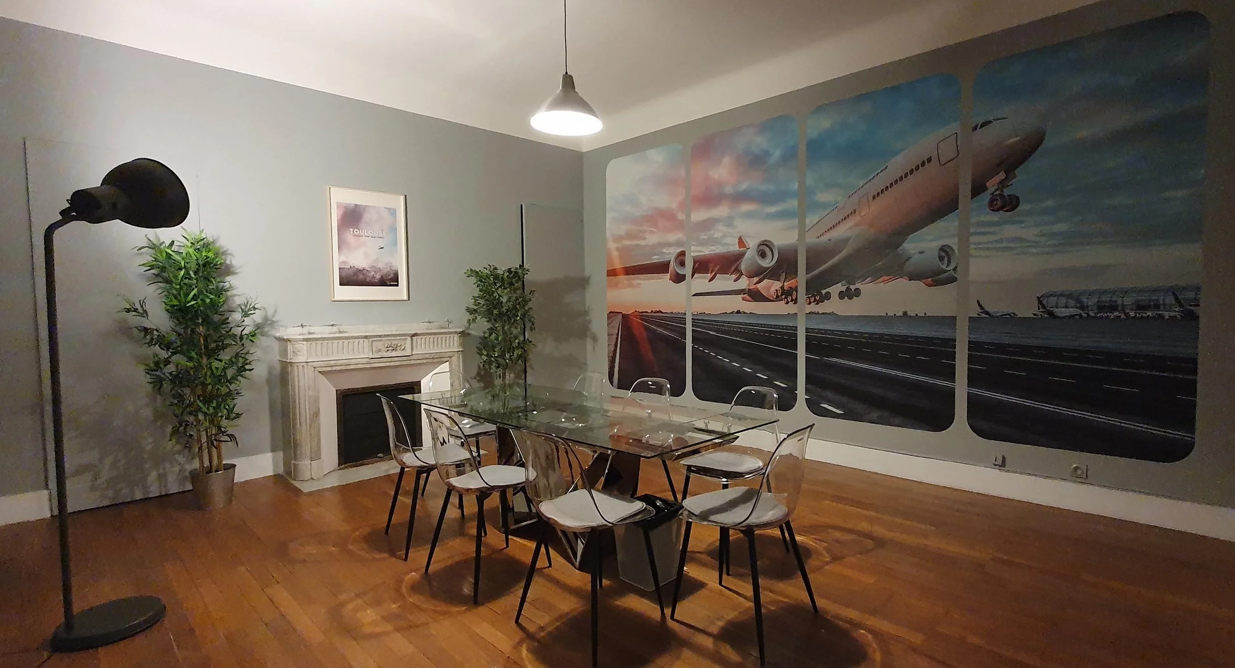 Salle à manger avec une grande fresque murale en papier peint imprimé.