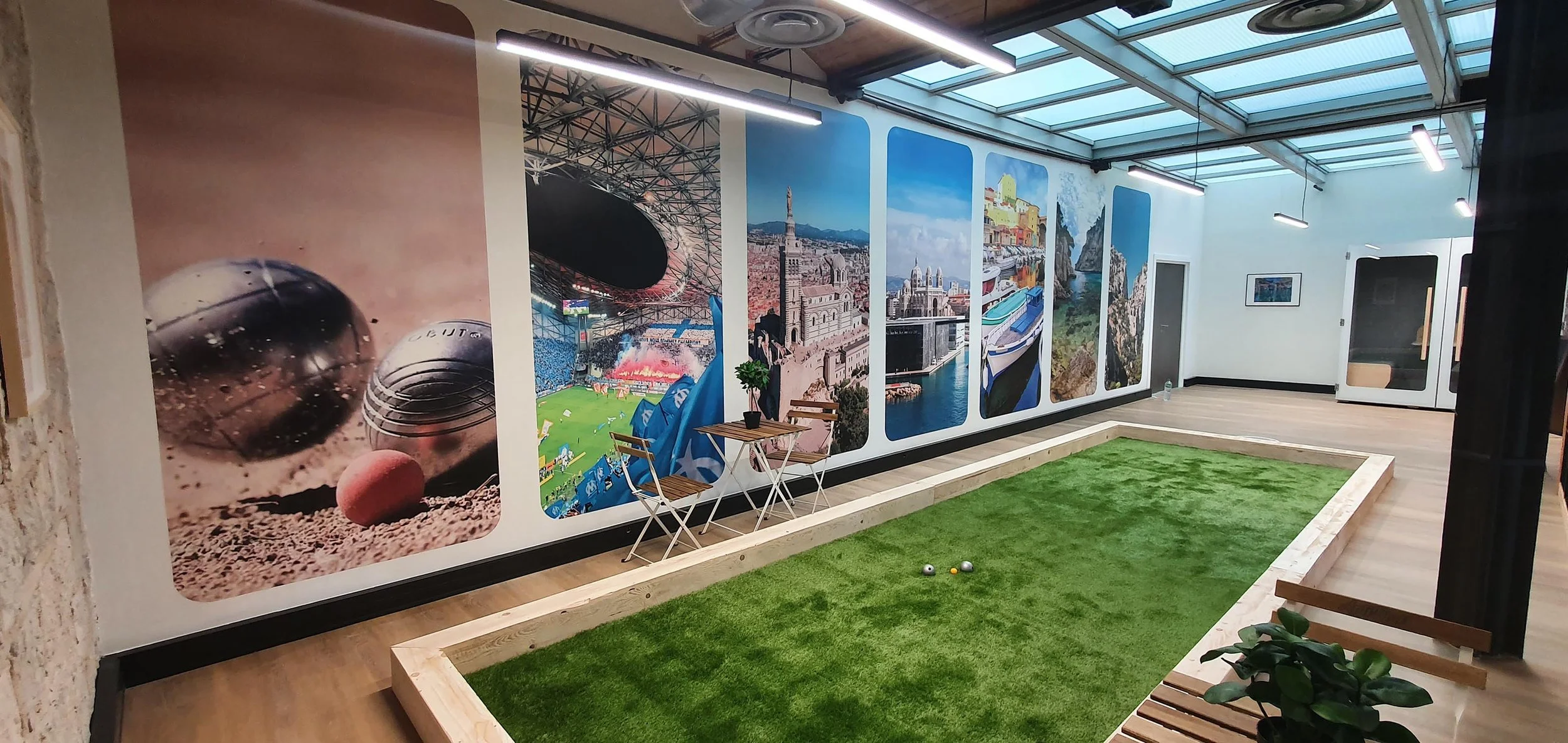 Aménagement d'un open space avec fabrication d'un terrain de pétanque indoor ou interieur et décor en papier peint imprimé.