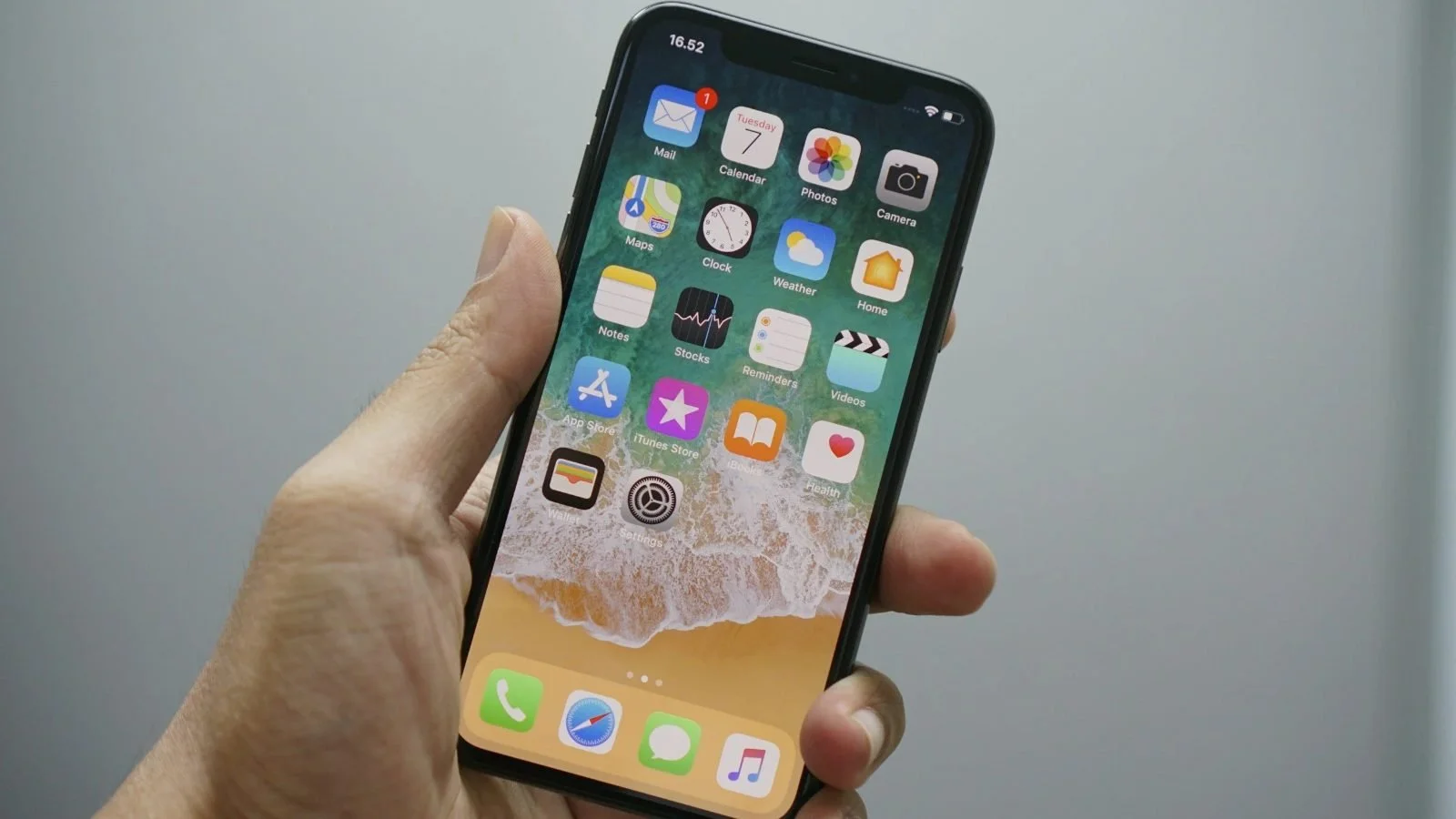 Hand holding an iPhone showing the home screen after setup