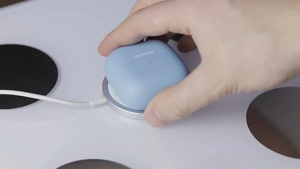 A blue case of Huawei FreeClip 2 earbuds charging wirelessly