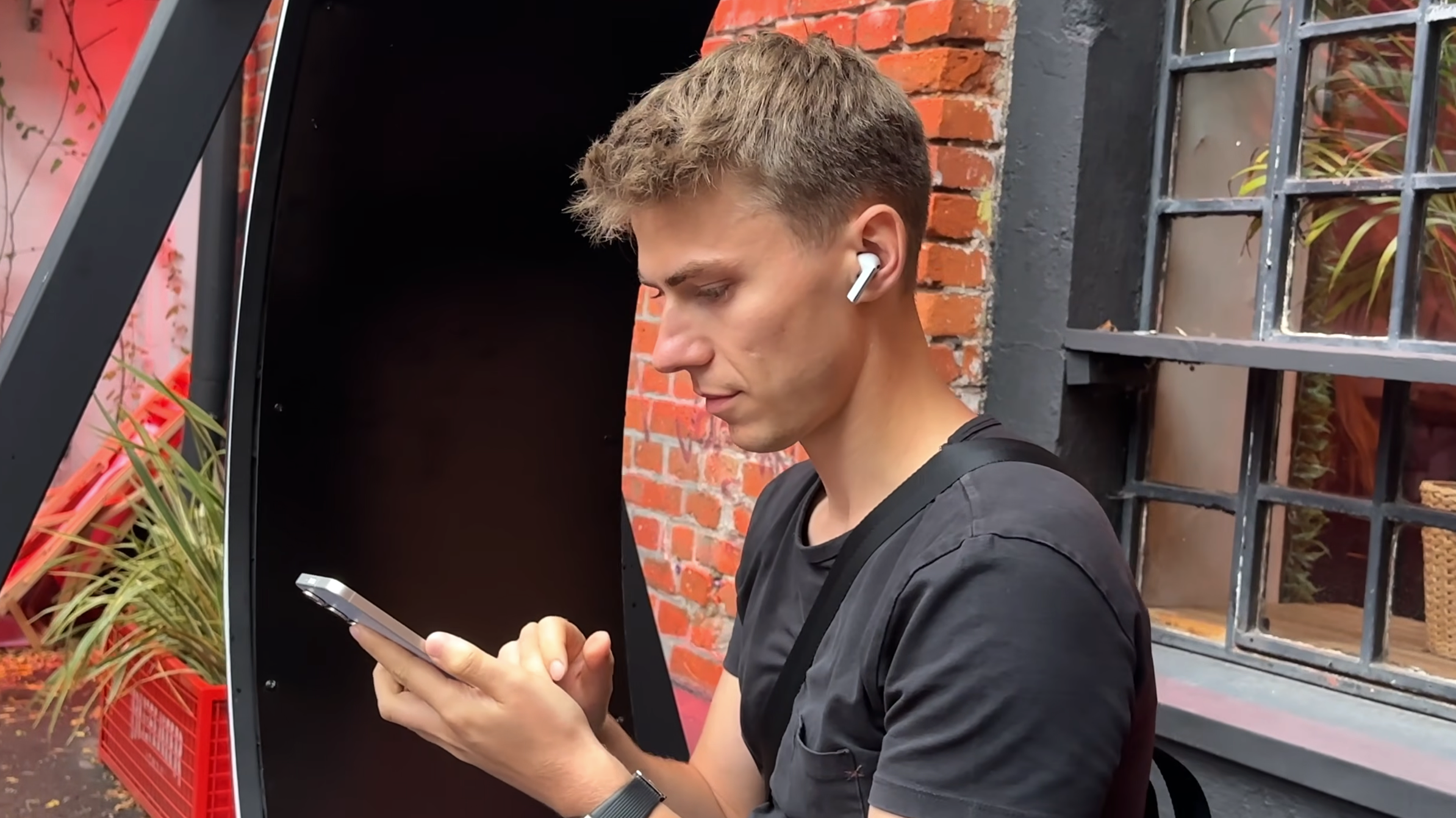A young man wearing white earbuds and listening to music
