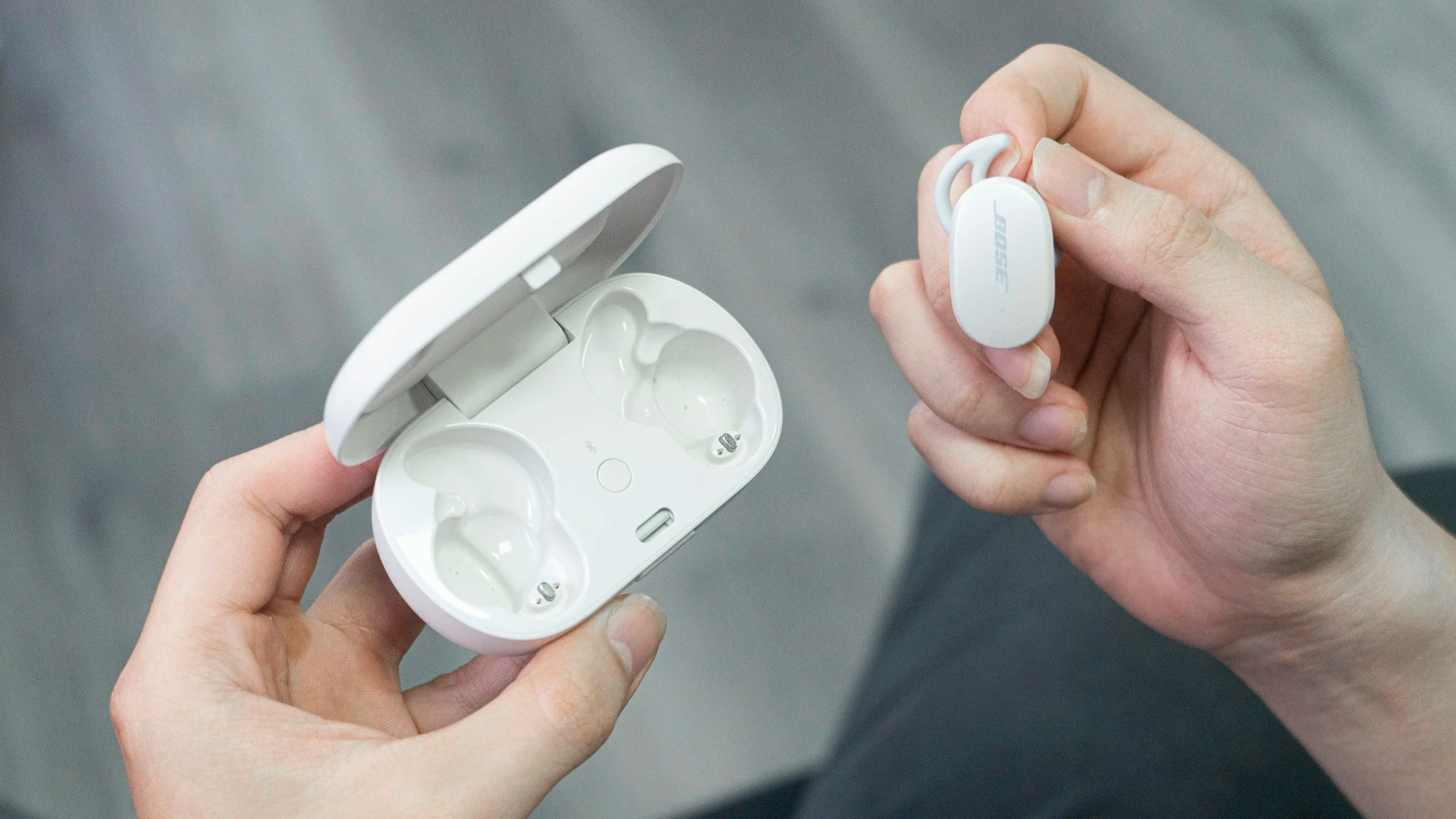 Female hands holding a pair of Bose QuietComfort earbuds