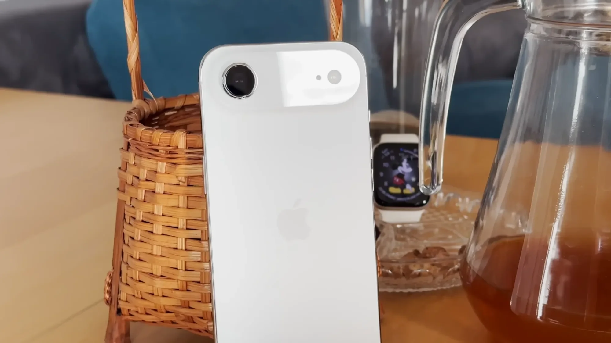 White iPhone Air leaning against a glass on a café table
