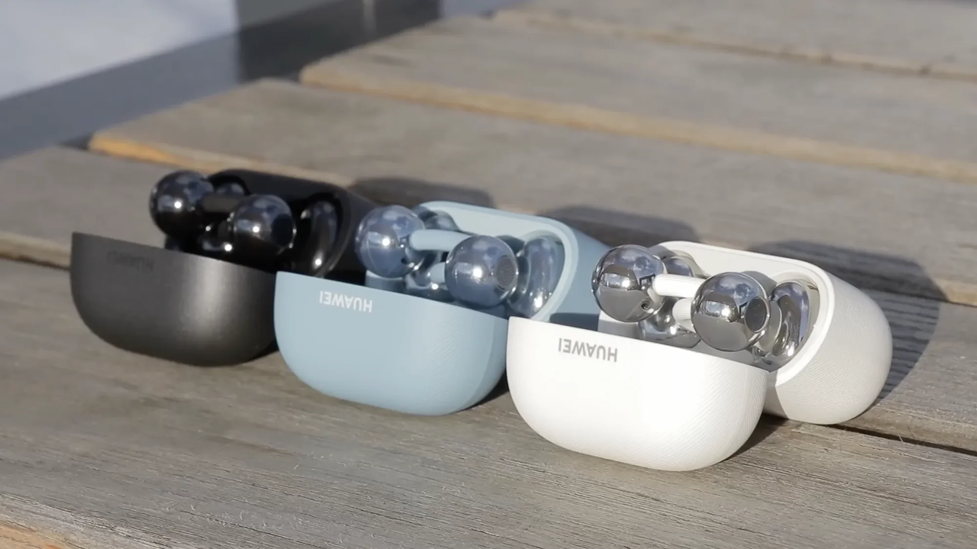 Open Huawei FreeClip 2 charging cases in white, blue and black