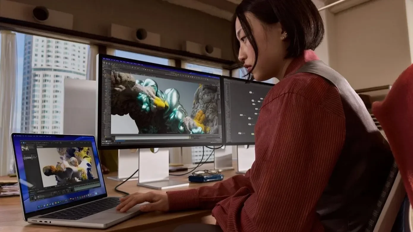 Woman editing video on a MacBook Pro at a desk