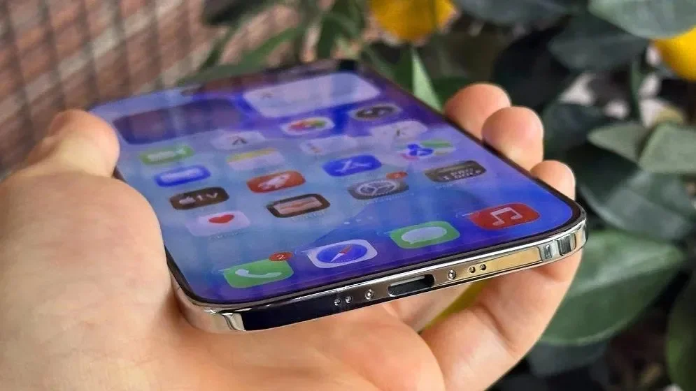Hand holding an iPhone Air showing its home screen