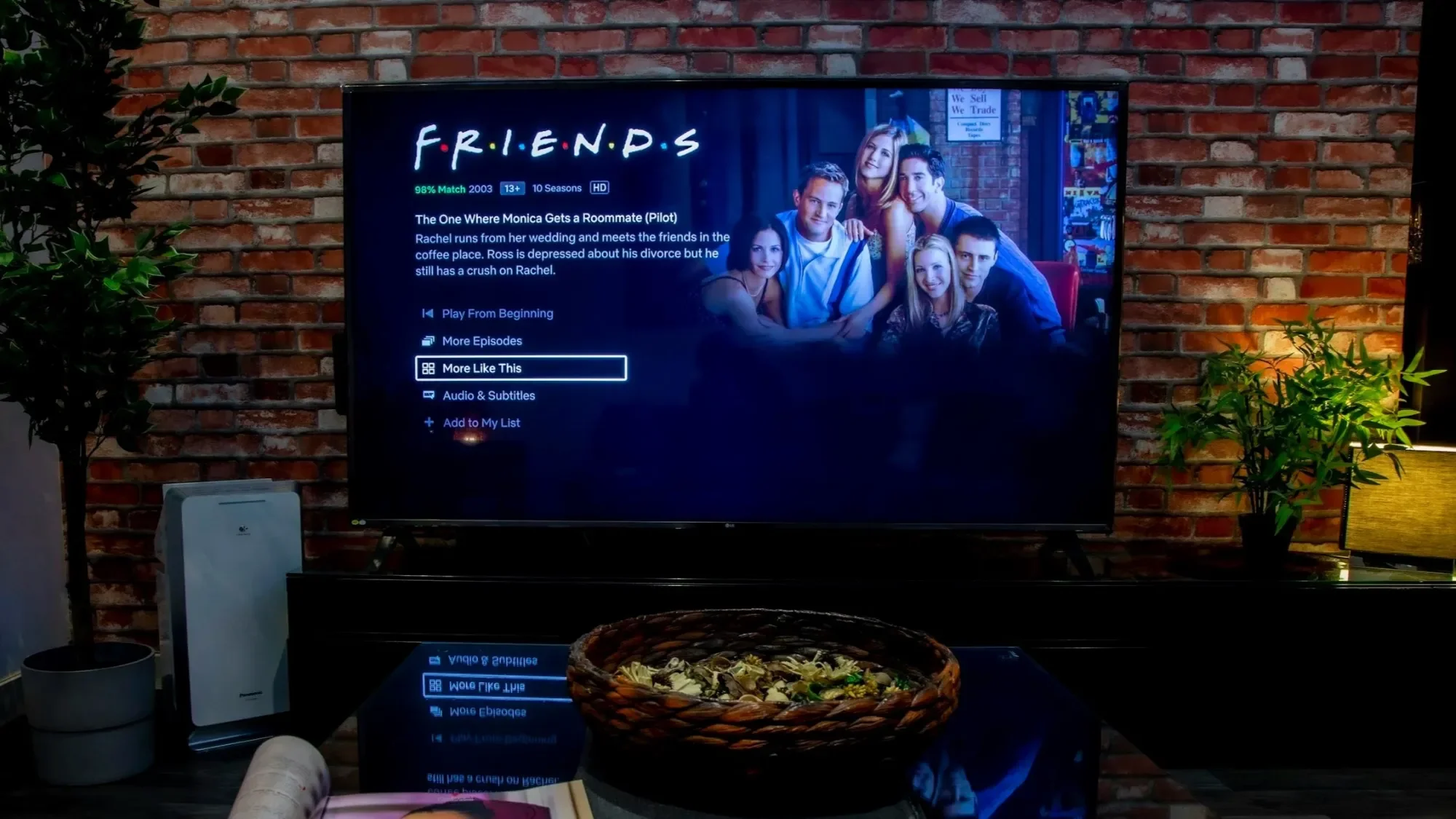 TV showing a show's title screen on a wooden stand surrounded by warm lights