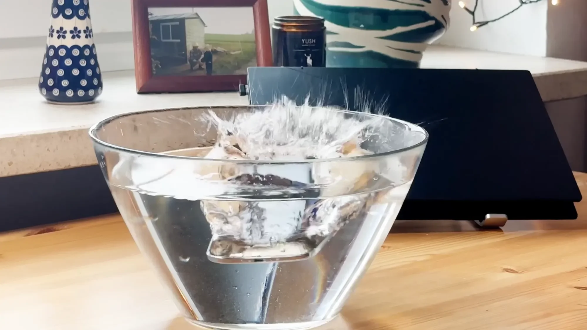 iPhone Air submerged in a glass bowl of water