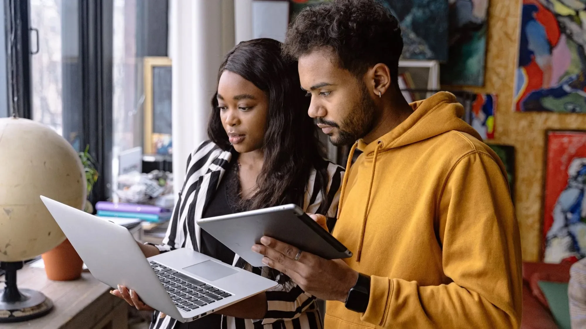 Two students studying together with a laptop and a tablet