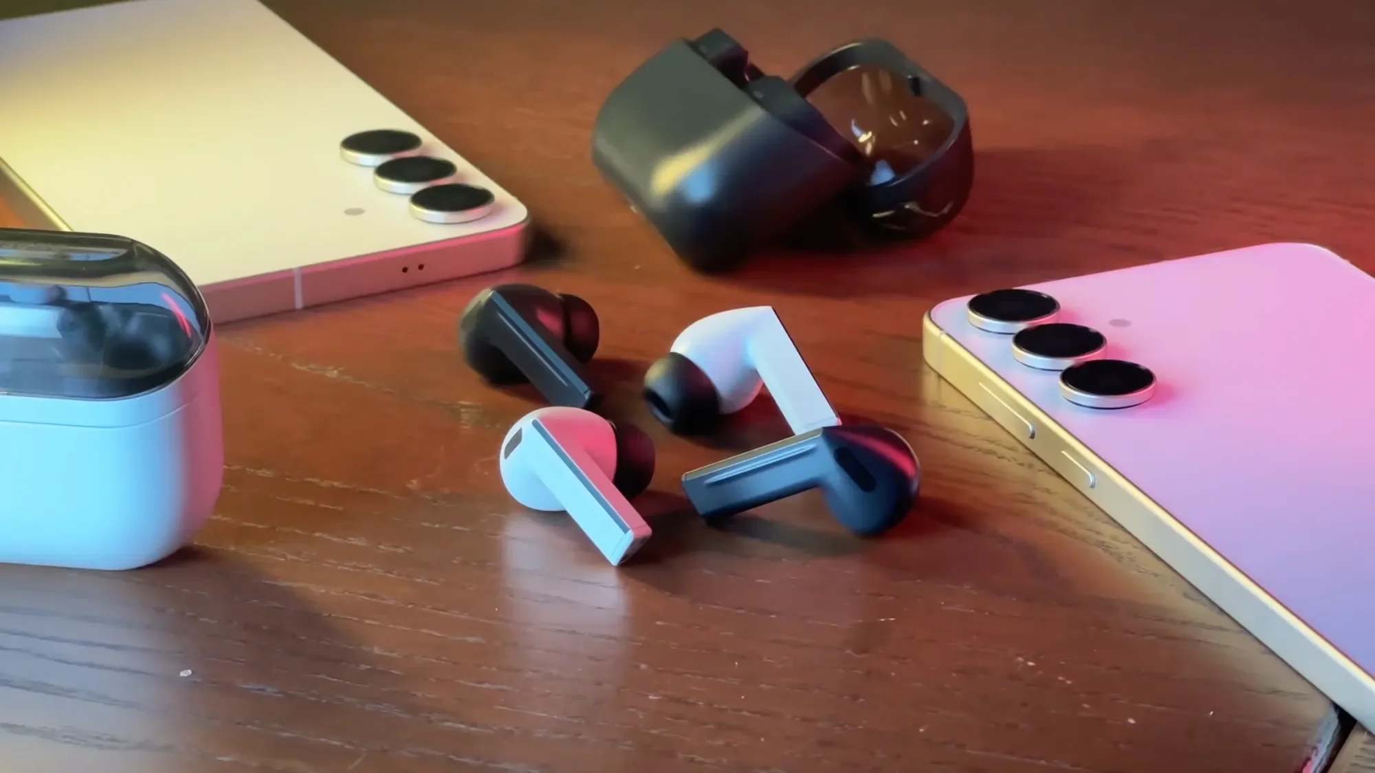 Galaxy Buds3 FE and a Samsung phone on a wooden desk