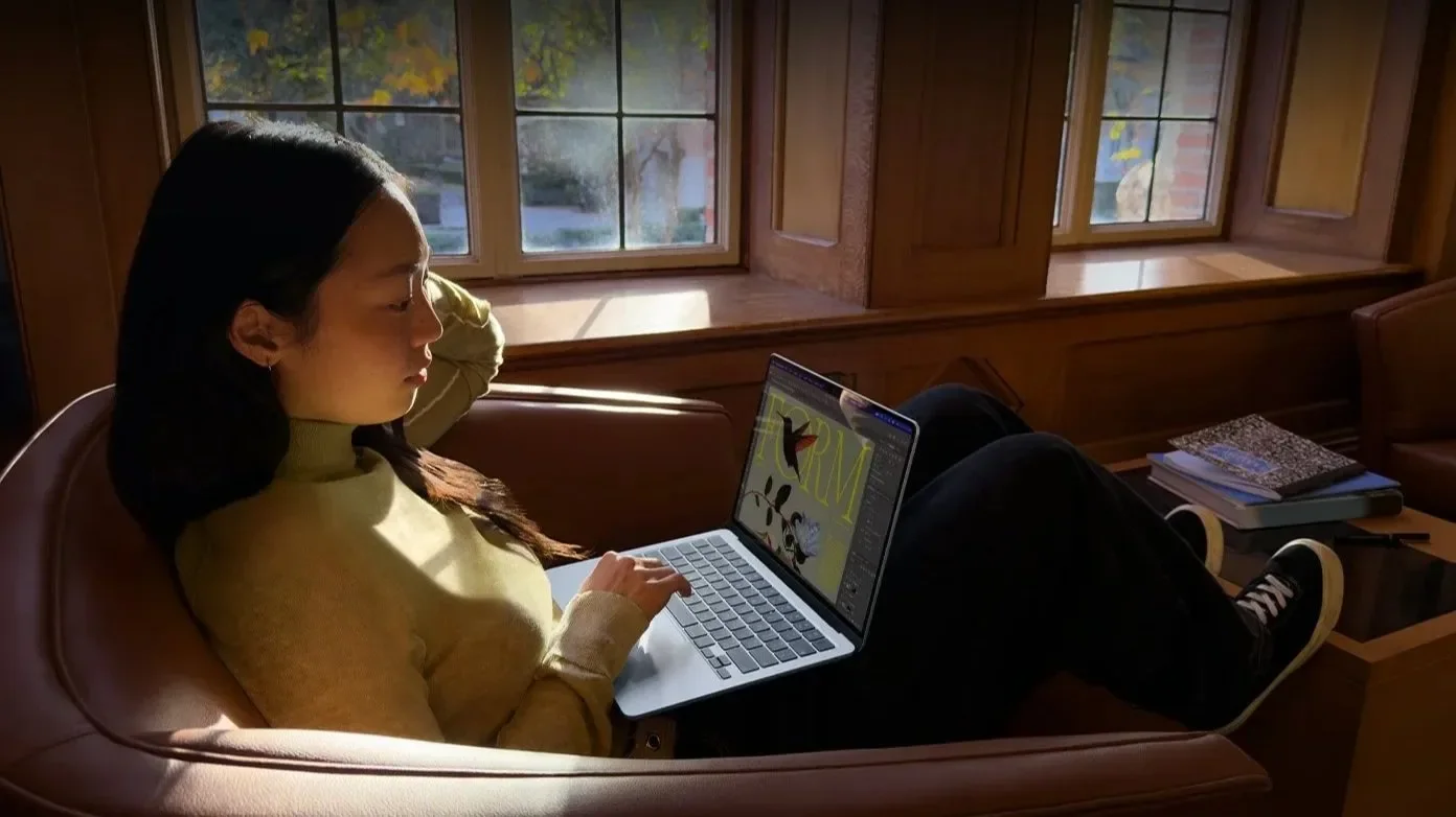 Woman using a MacBook on a sofa in a cozy room at night