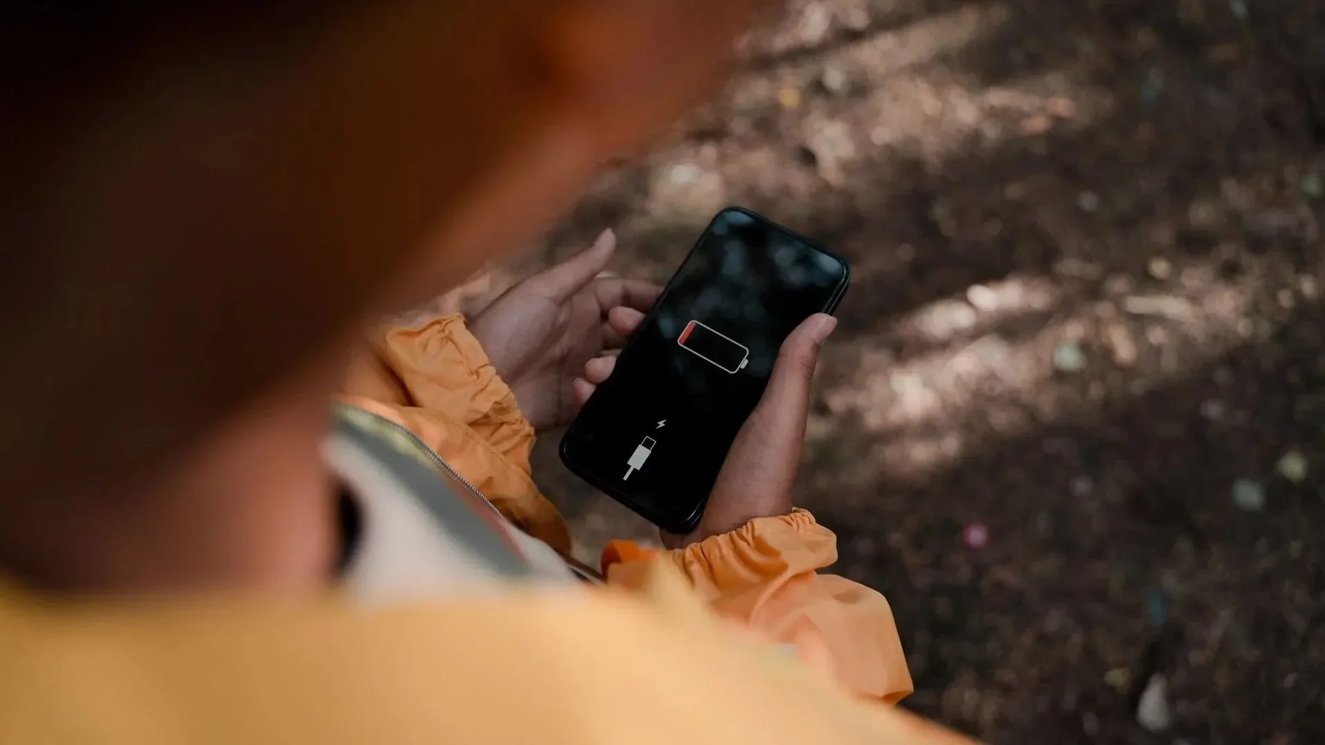 Person holding a phone with a drained battery