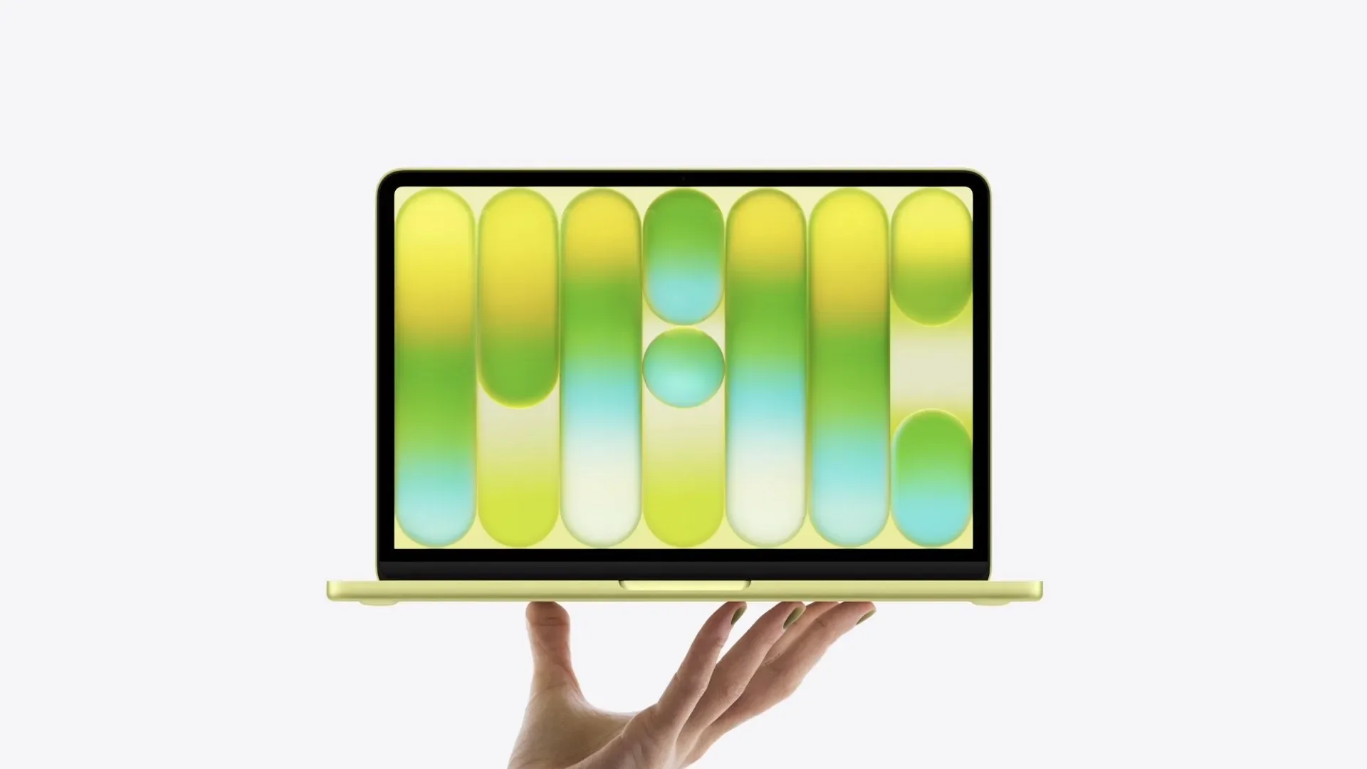 Hand holding a yellow MacBook Neo