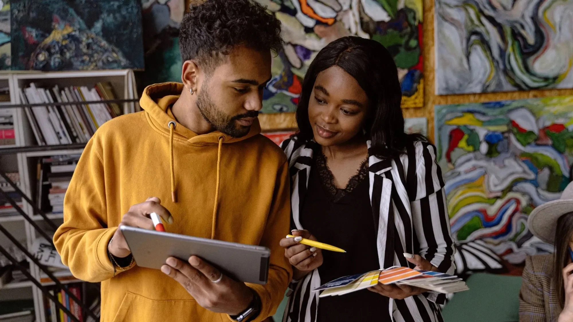Two students looking at a tablet together in a colorful room