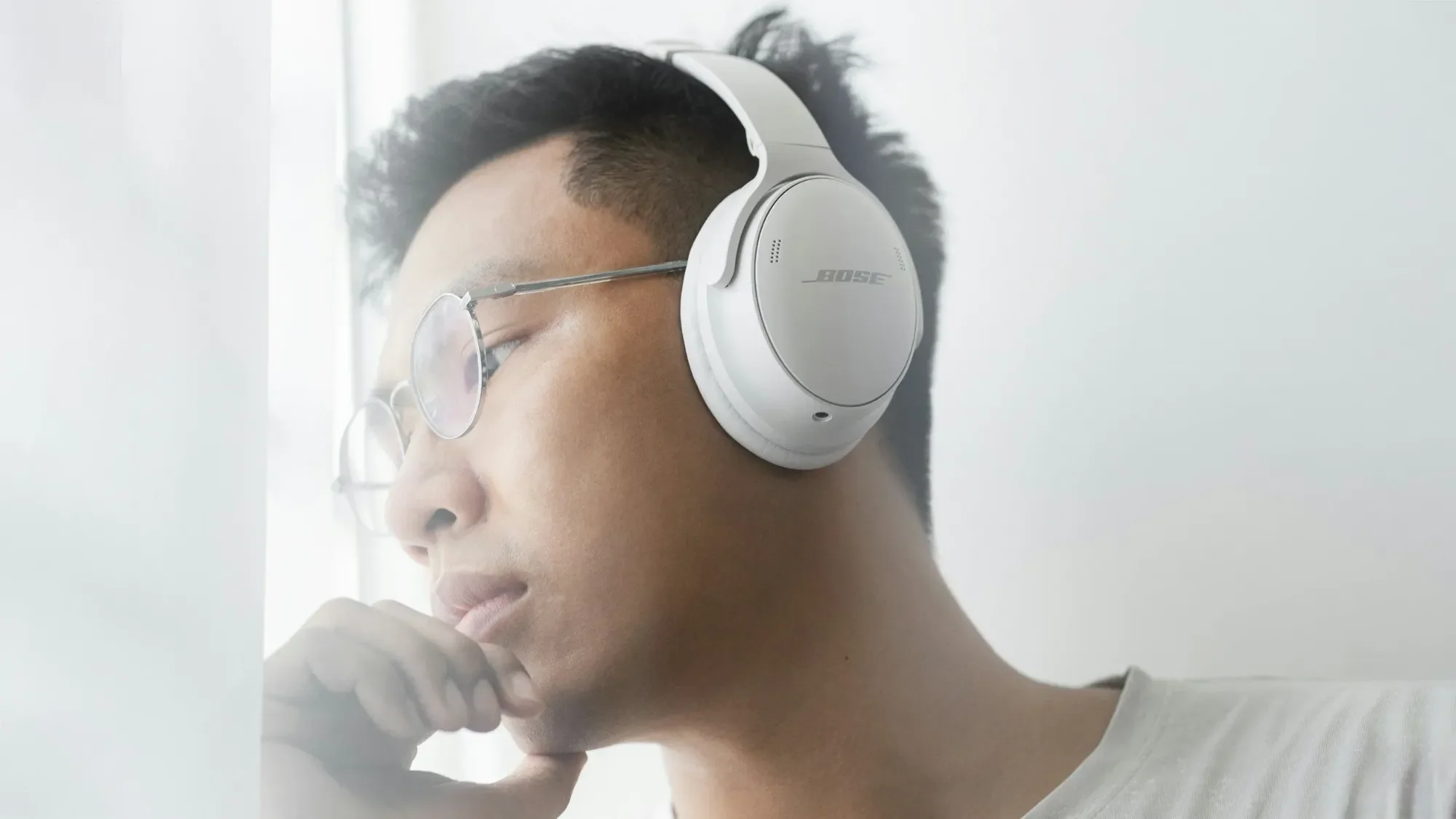 Young man wearing white Bose headphones