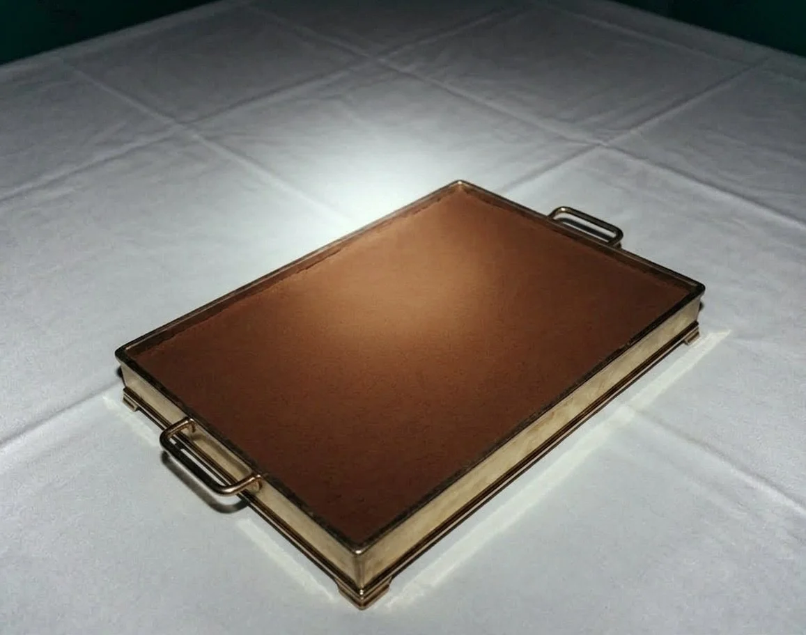 A rectangular, brown leather-bound book placed on a white tablecloth.