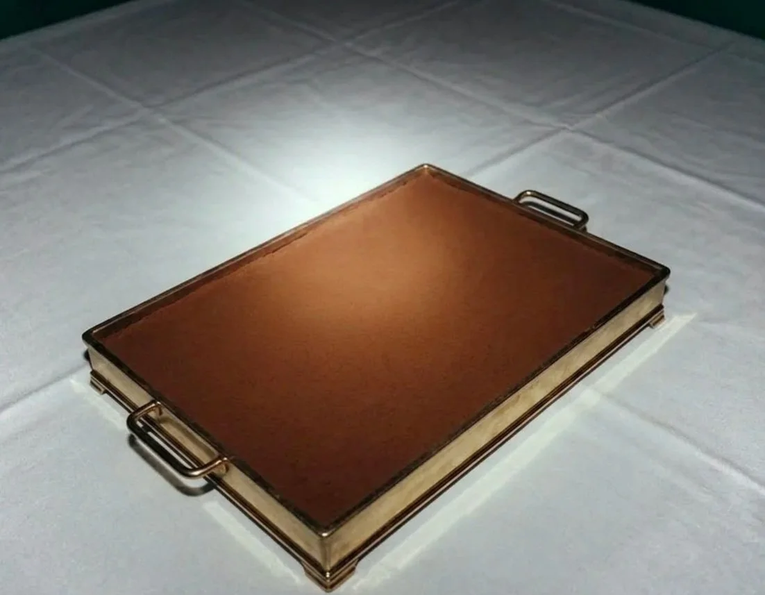 A rectangular metal serving tray of espresso tiramisu with two handles, placed on a white tablecloth.
