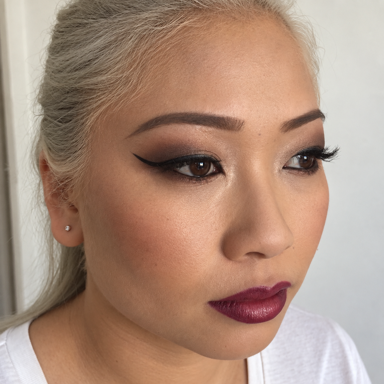 Editorial makeup with winged eyeliner and berry lips
