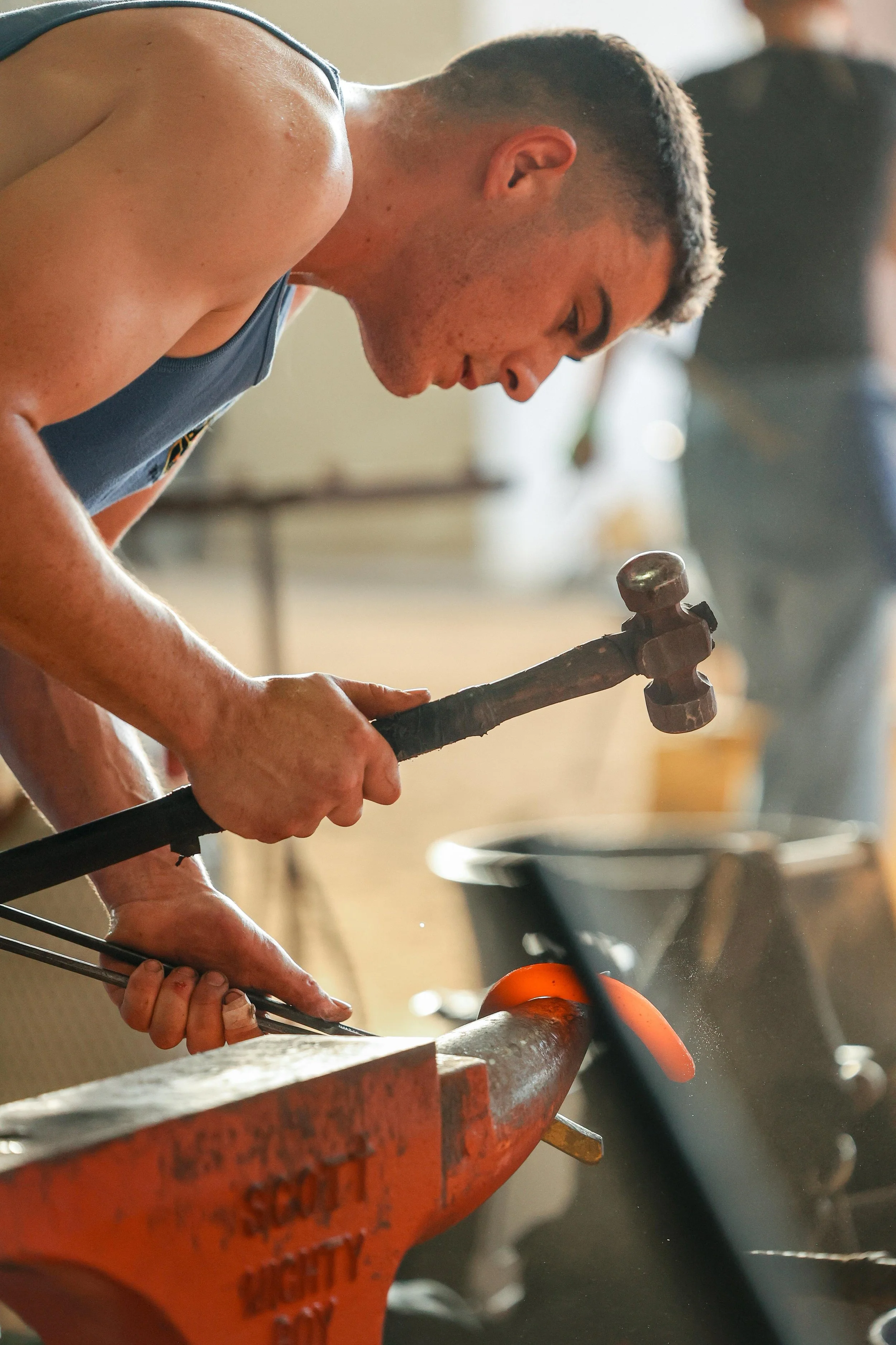 Man forging a horseshoe by hand over an anvil