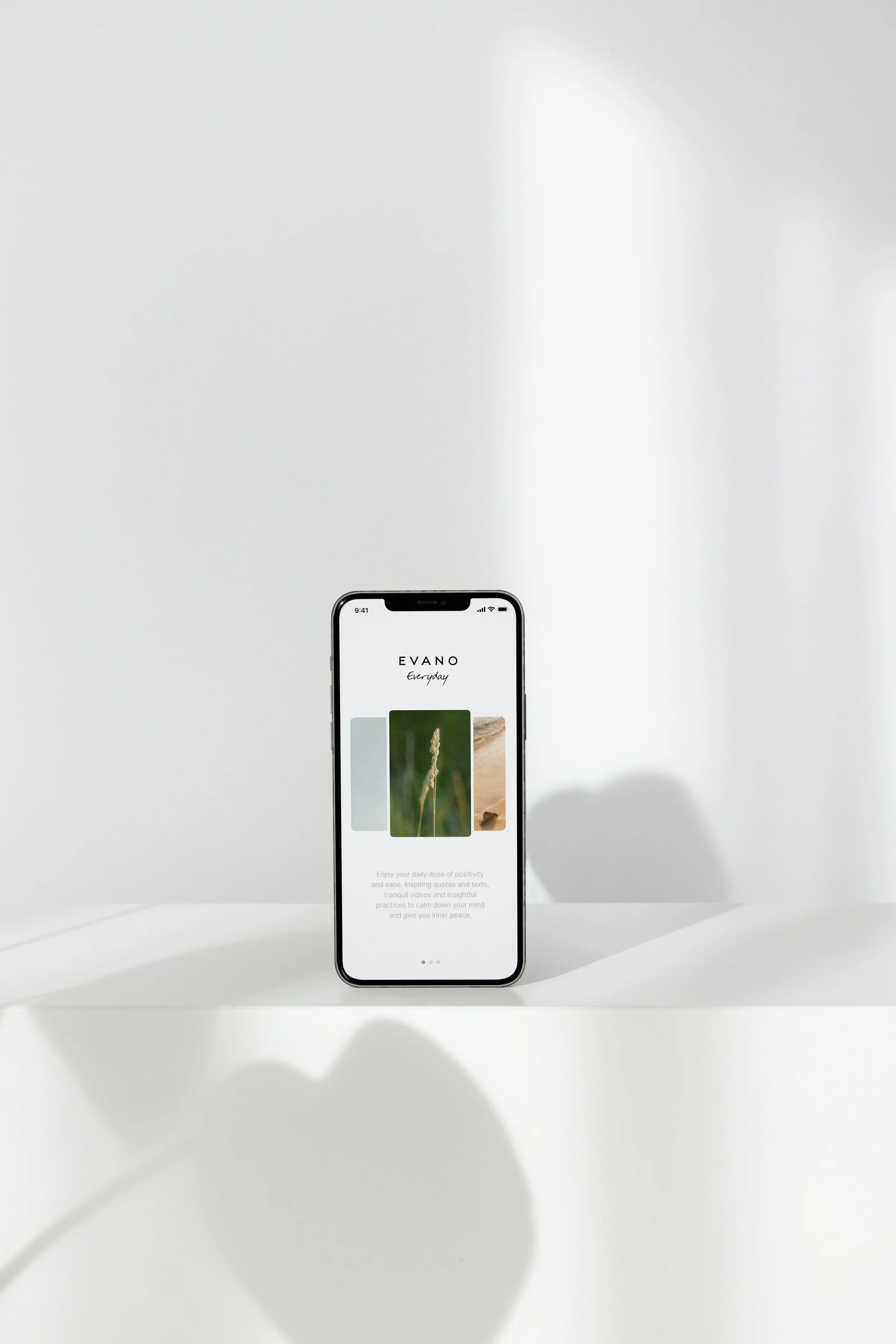 Smartphone displaying the home screen of an app called EVANO Everyday with images of nature and an inspirational quote on a white background.
