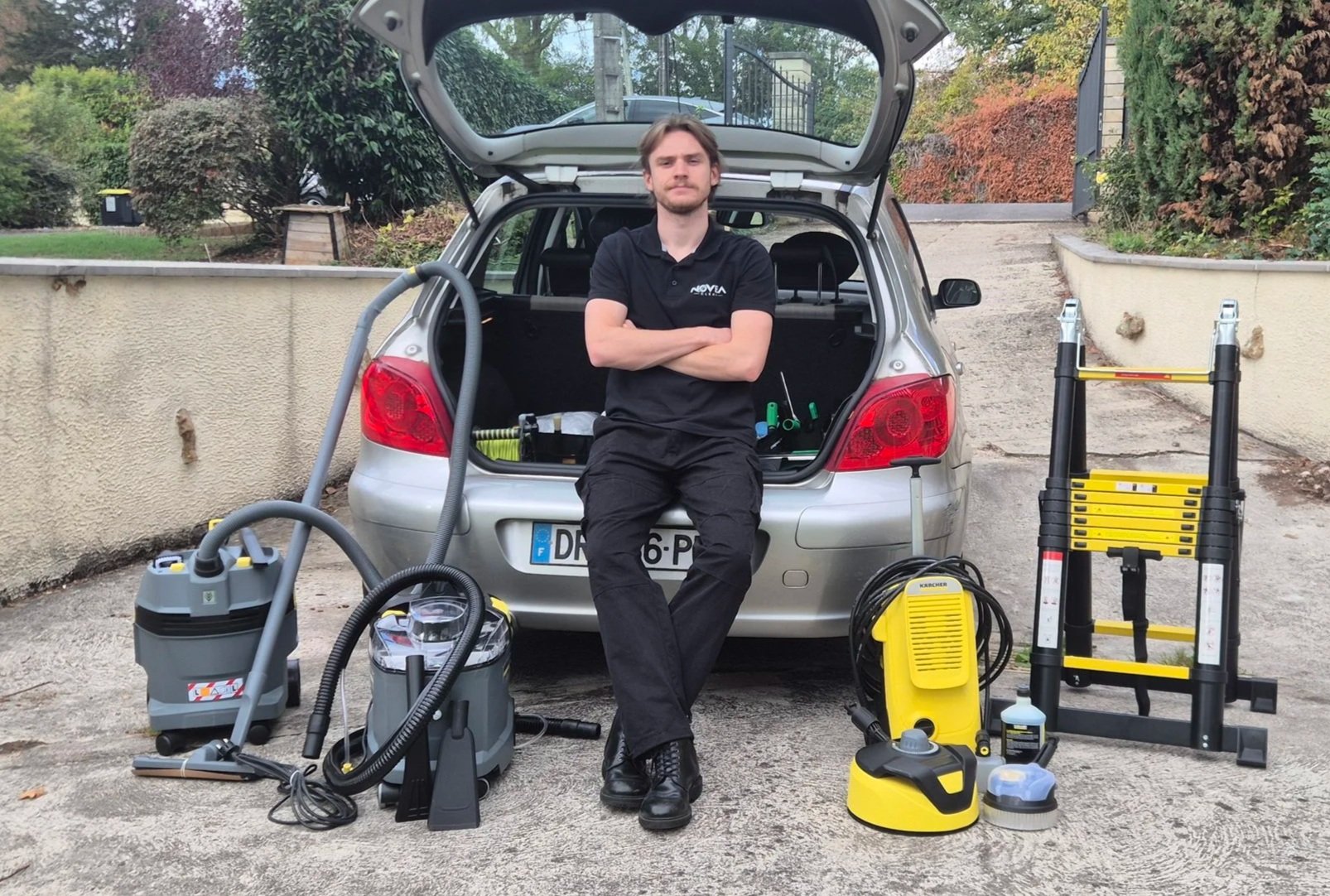 Lucas le fondateur de Novea Clean pose devant son matériel professionnel : nettoyeur haute pression, extracteur-injecteur, aspirateur toutes surfaces.