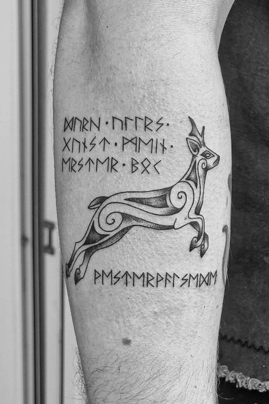 Tattoo eines laufenden fantastischen Wesens mit Runen und indischer, nordischer oder skandinavischer Symbolik. Es ist auf einem Oberarm oder Unterschenkel.