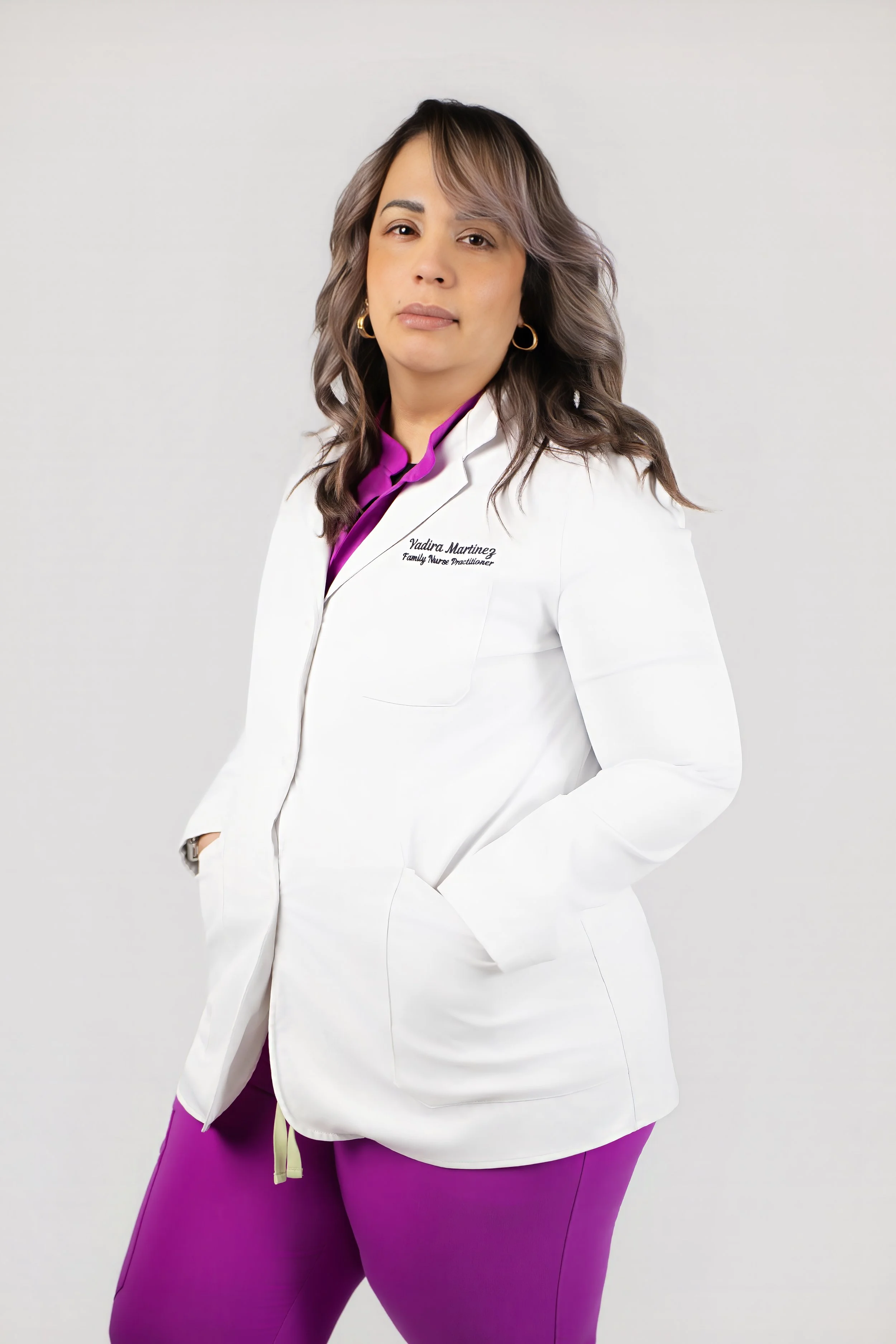 Yadira Martinez, MSN, APRN, FNP, standing in a white blazer with purple accents.