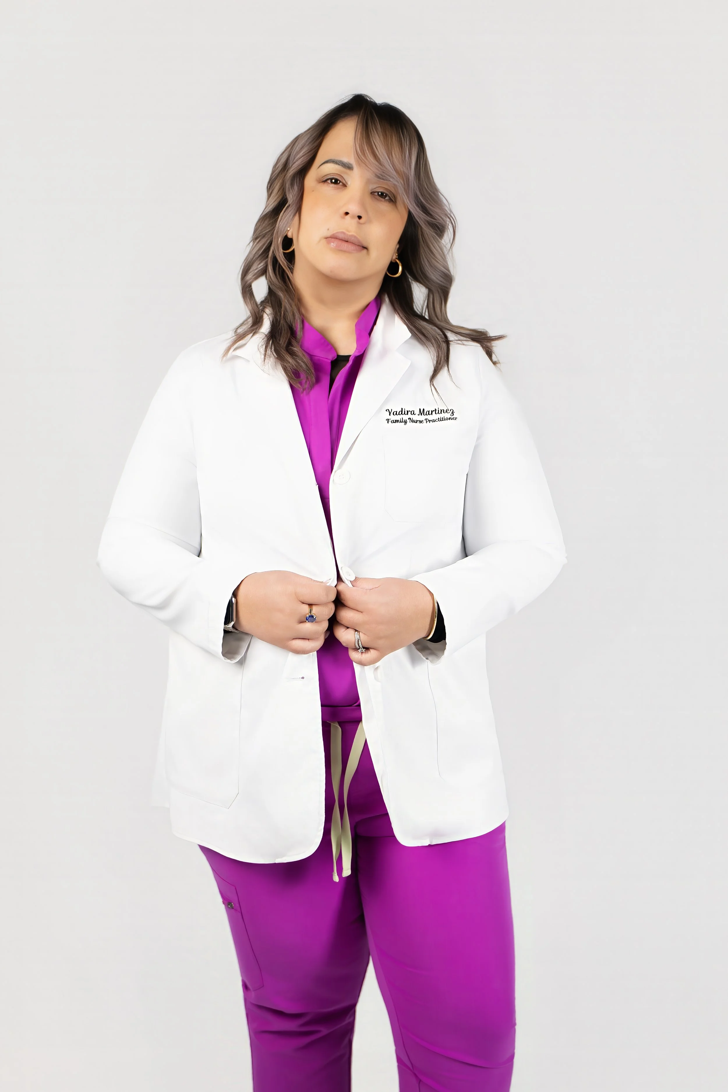 Yadira Martinez, MSN, APRN, FNP, wearing white clinical coat over purple scrubs.