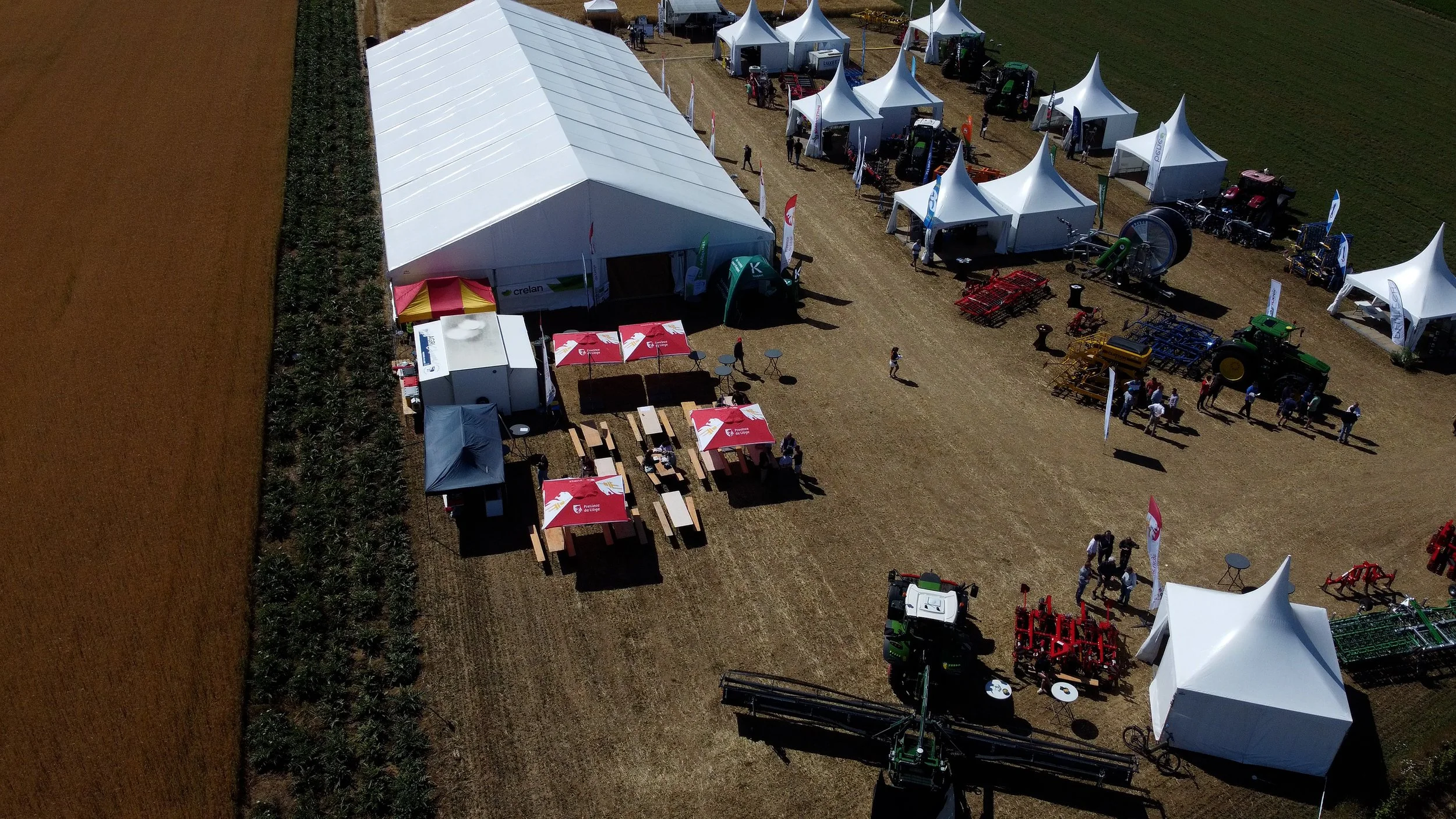 Festival Agriculture  stand d'exposition agricole  tentes blanches, tracteurs machinisme agricole, et équipements agricoles, en plein air sur un champ.