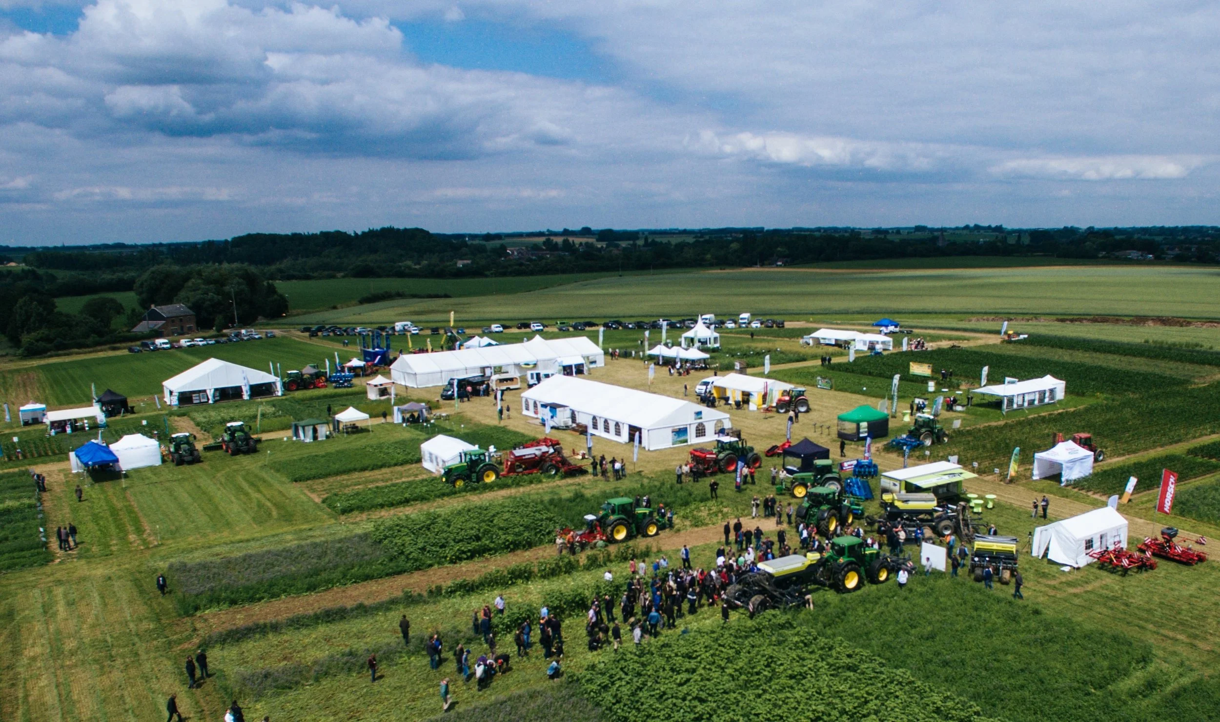 Festival de l'Agriculture foire agricole en plein air avec plusieurs stands, tracteurs et visiteurs
