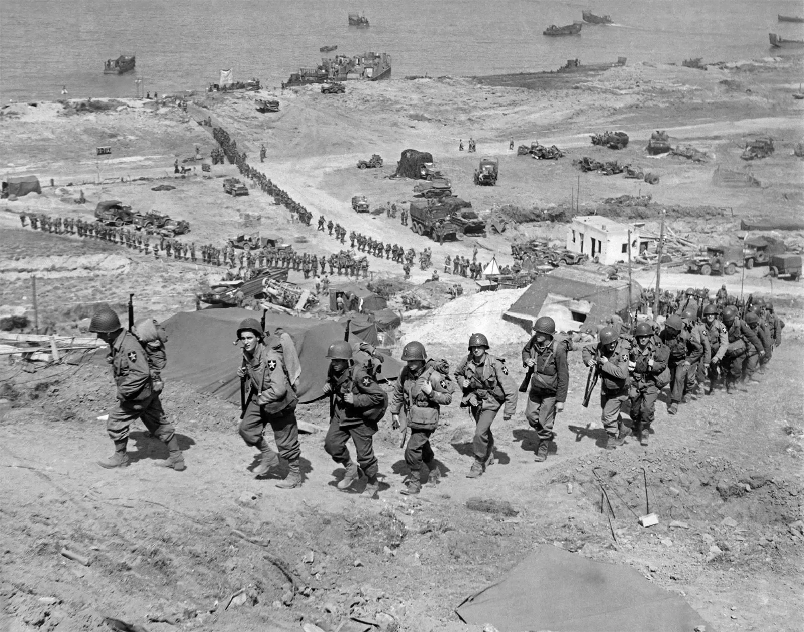 US 2nd Infantry Division walking up the bluffs at Omaha Beach after D-Day in Normandy France