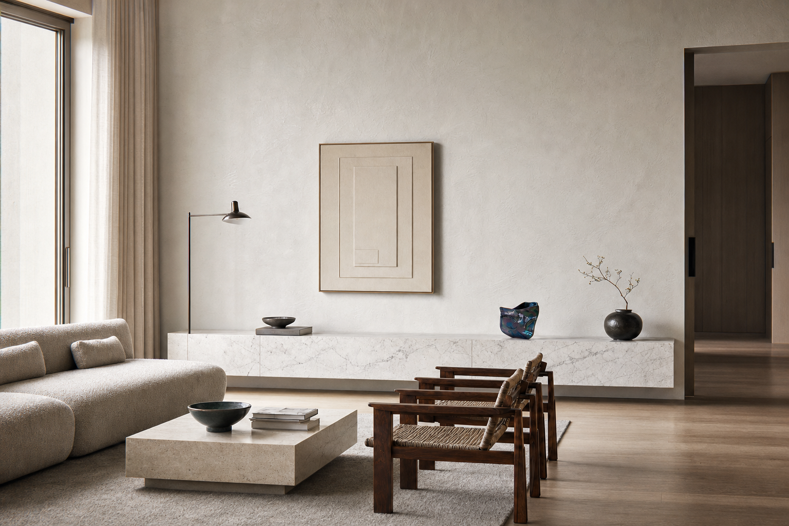 Interno di soggiorno con divano beige, tavolino in pietra, sedie di legno, parete chiara con quadro e oggetti decorativi in stile minimalista.
