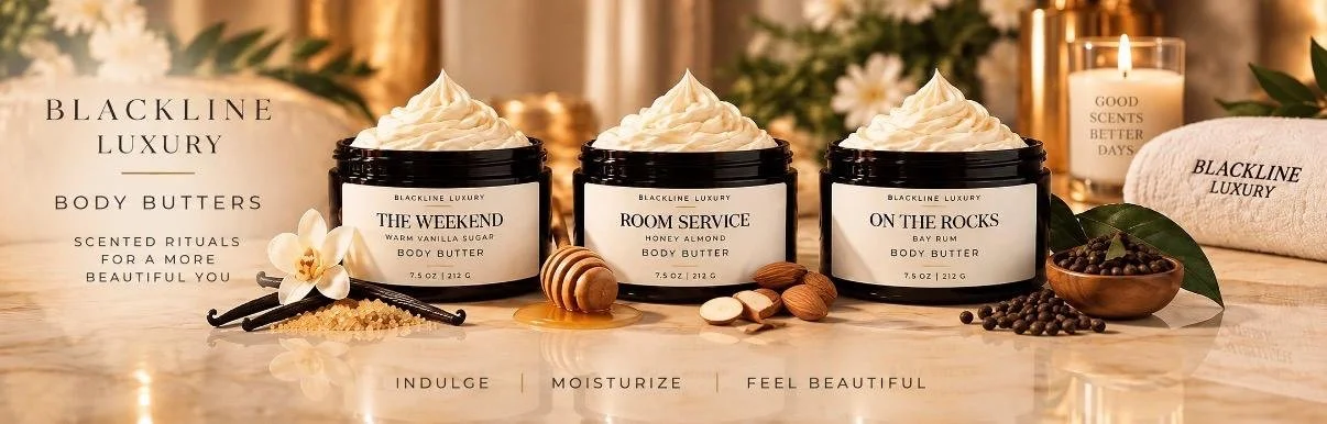 Three jars of Blackline Luxury body butters labeled The Weekend, Room Service, and On The Rocks, displayed on a table with honey, almonds, and vanilla beans, along with candles, flowers, and a towel, in a luxurious setting.