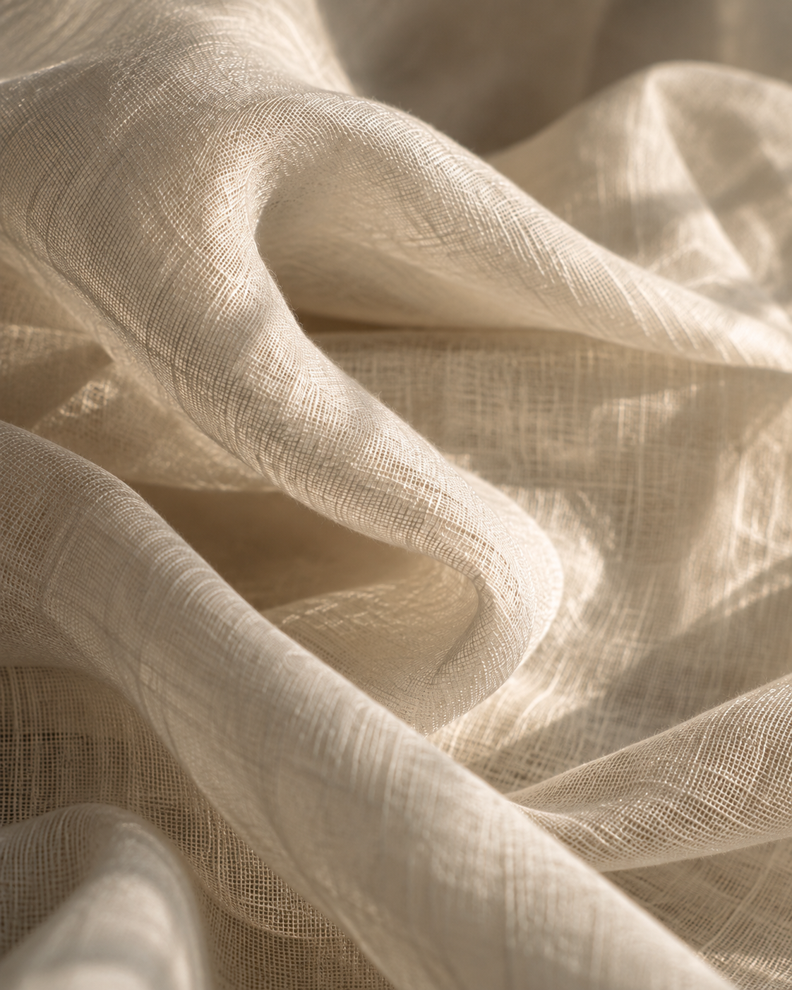 Close-up of sheer, light-colored, textured fabric with soft folds and drapes.