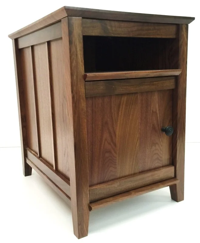 A wooden nightstand or small cabinet with a single drawer and a door with a round knob.