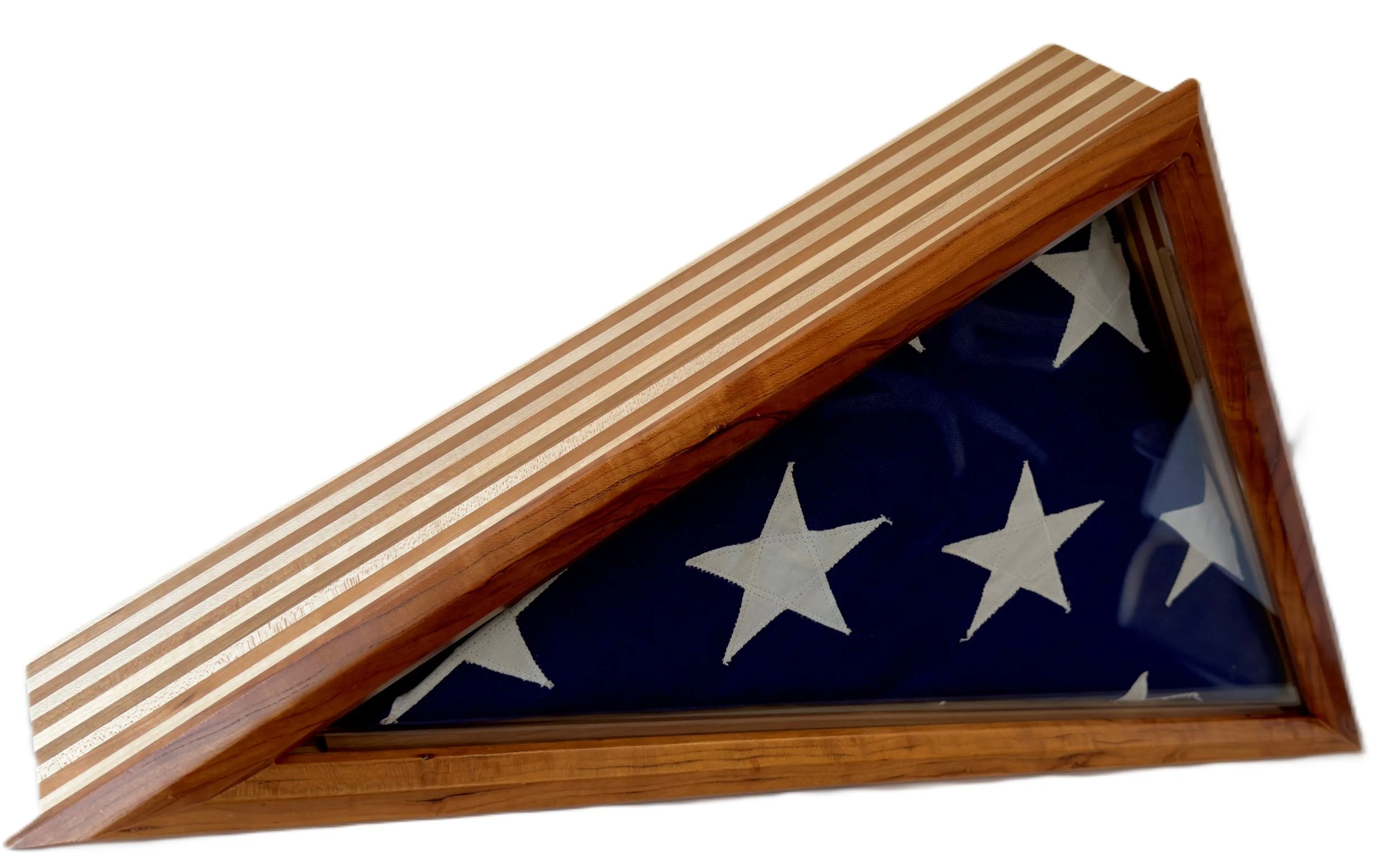 A wooden display case with a glass top, containing a folded American flag with white stars on a blue background, and striped fabric visible at the edges.