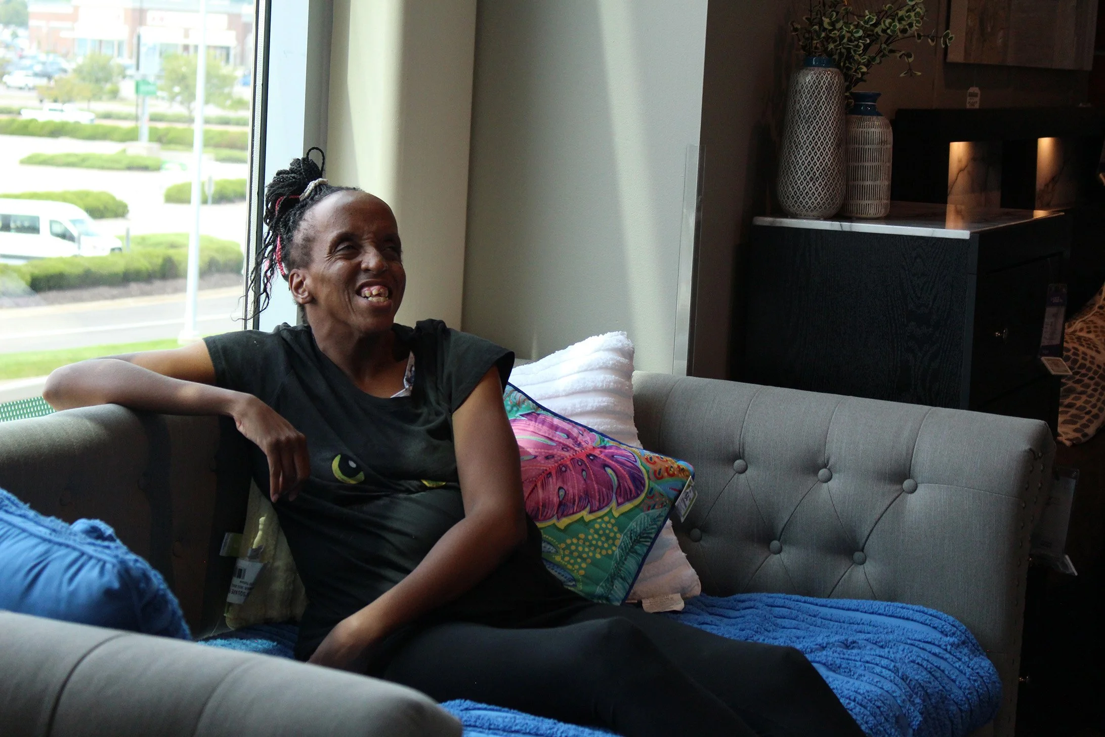 Client of residential services support smiling on her couch