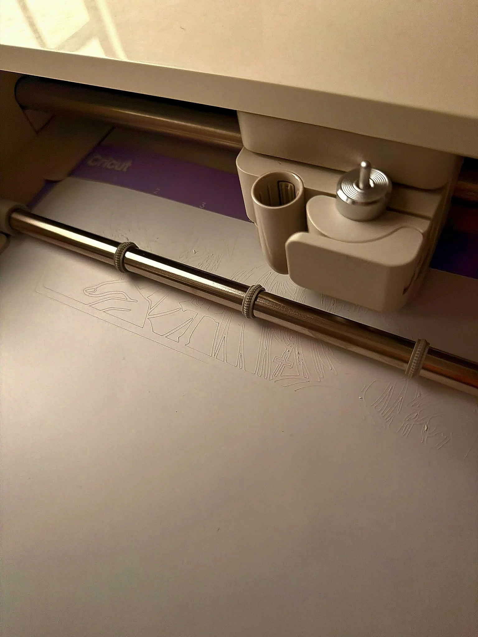 Close-up of a white drawer with a metallic handle and a small metallic knob, partially open revealing some papers underneath.