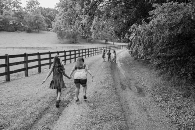 Children walking hand in hand along a country path at Refuge Ranch in Lynnville Tennessee.