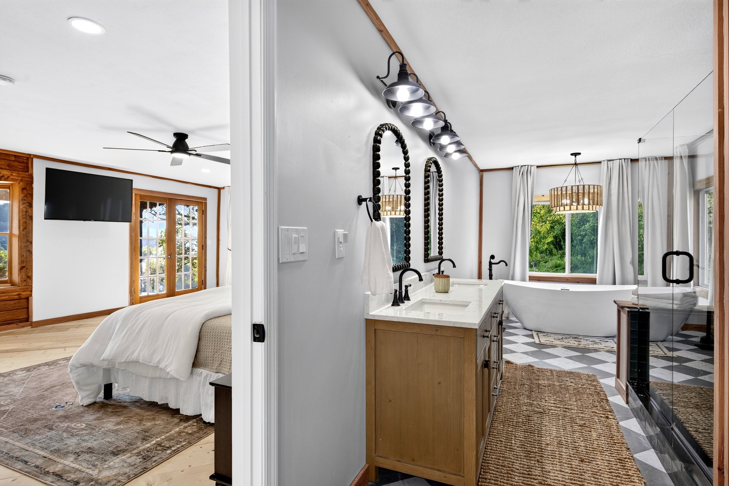 Spacious master suite and adjoining bathroom at Refuge Ranch, featuring a king bed, soaking tub, walk -in shower, and double vanity.
