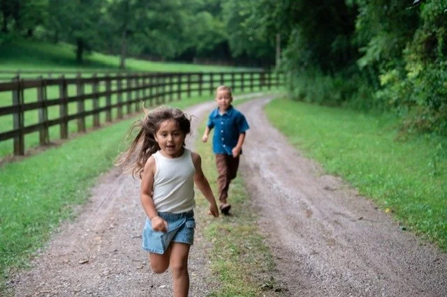 two Children running along a country path at Refuge Ranch in Lynnville Tennessee.