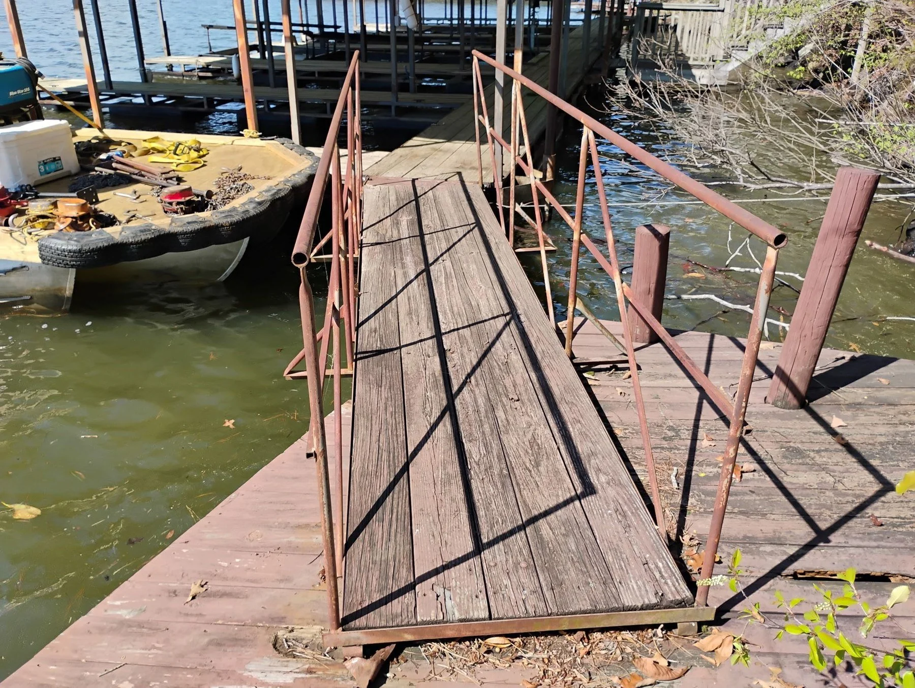 Work skiff loaded with chain and winches beside a walkway lifted for a dock move