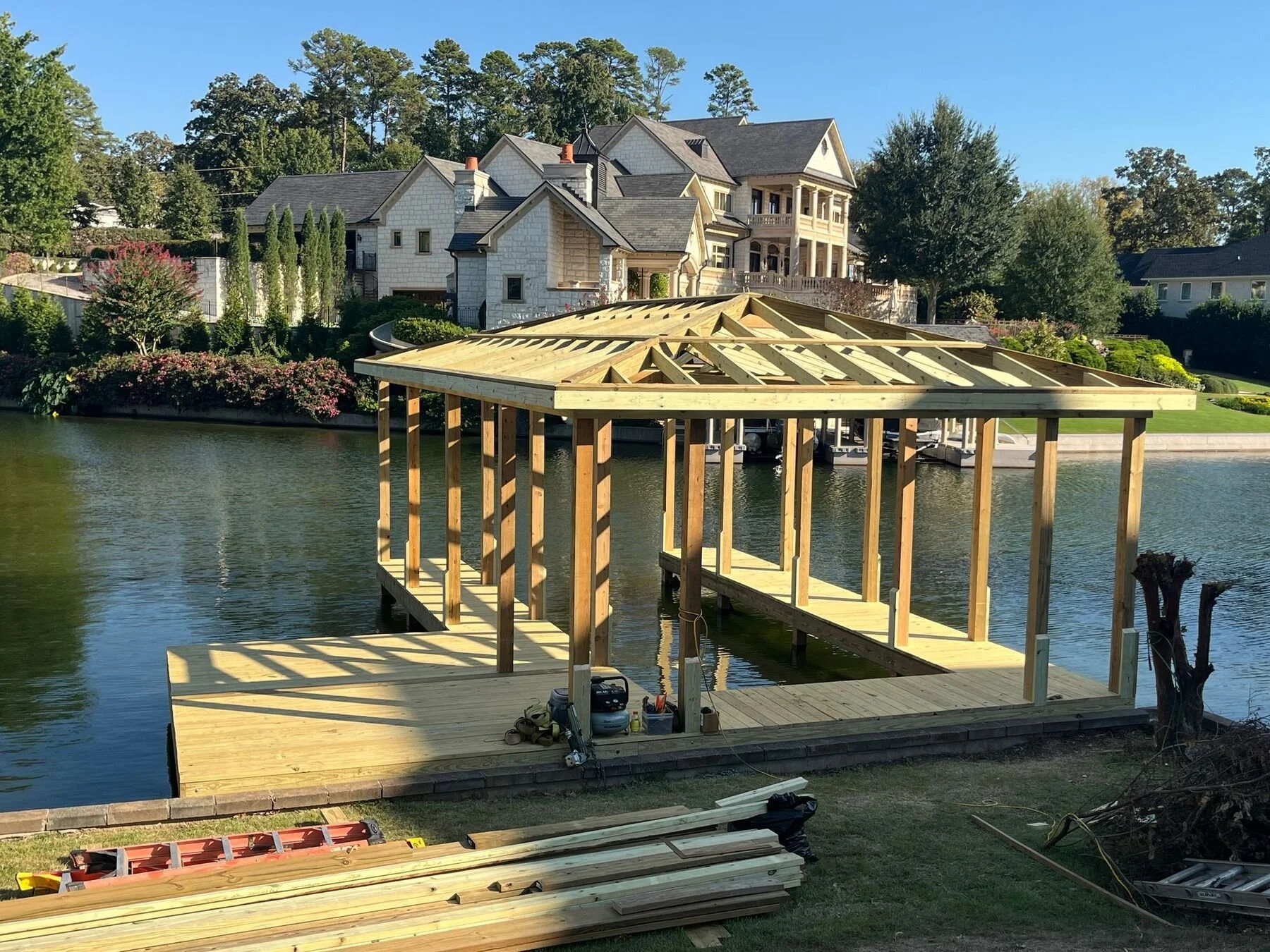Large covered boat dock under construction in front of a lake house, Lake Hamilton