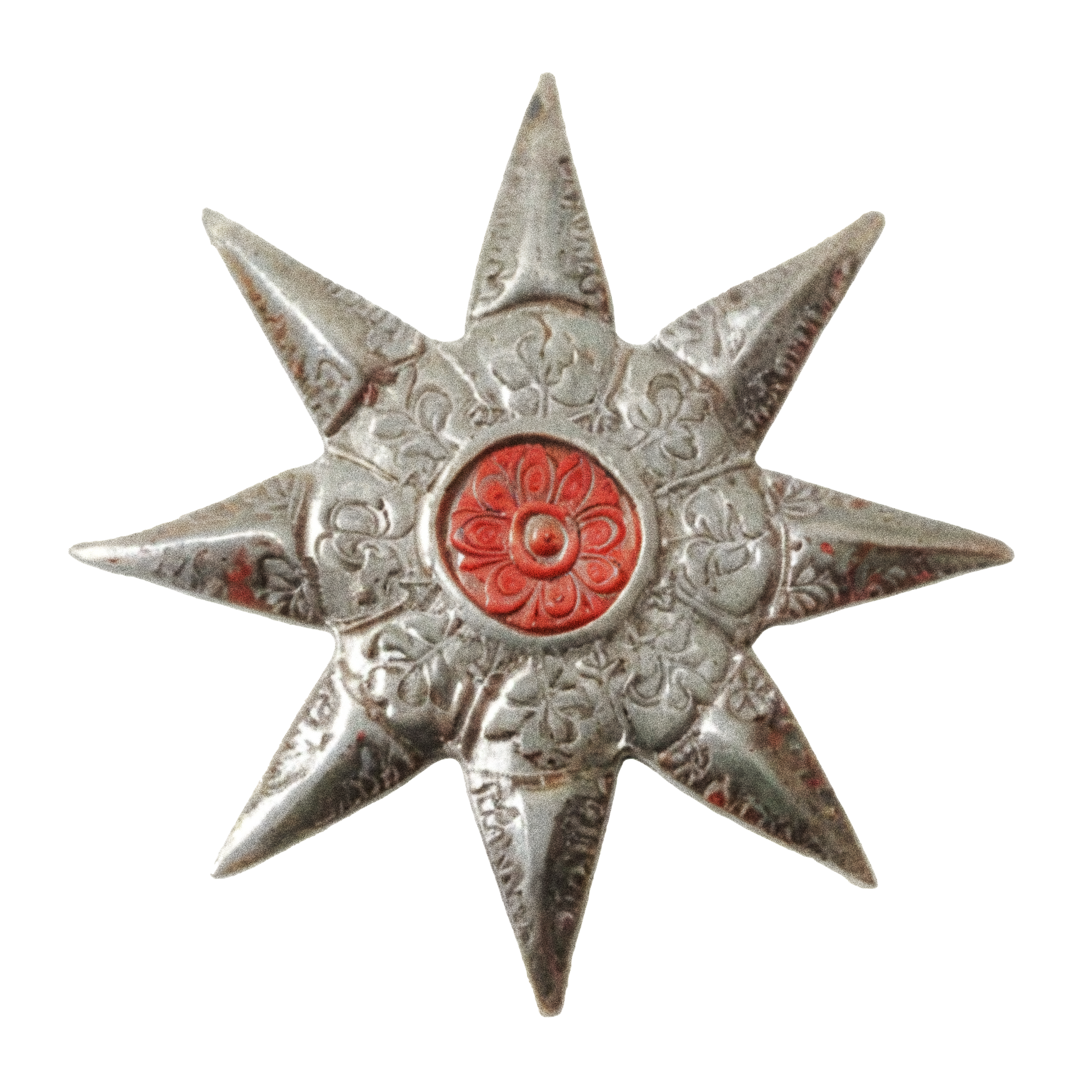 Close-up of a decorative metal star with intricate floral patterns and a red central design.