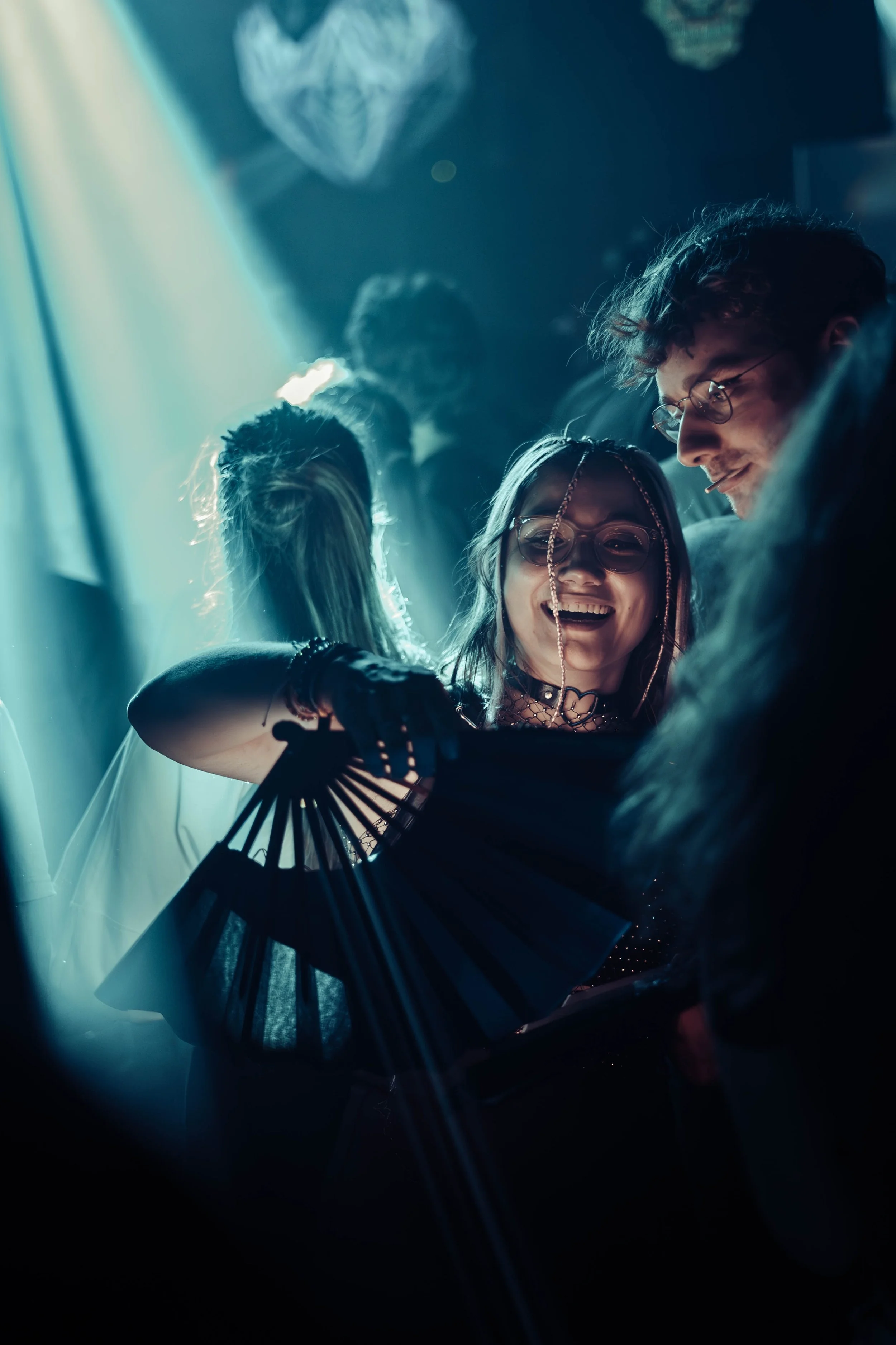 Two people smiling at a social event with dark background and dim lighting.
