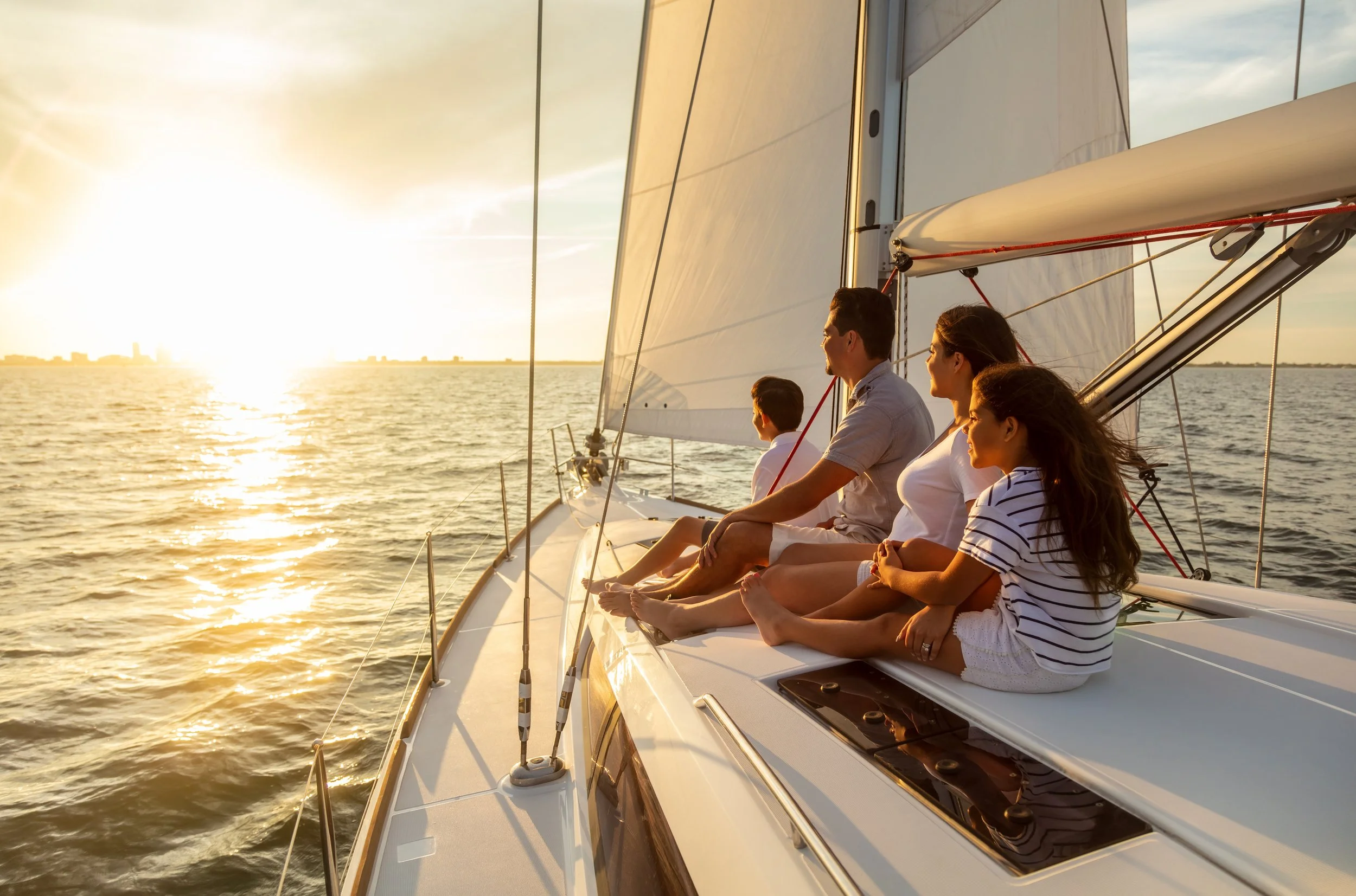 A family on a boat looking at the sunset