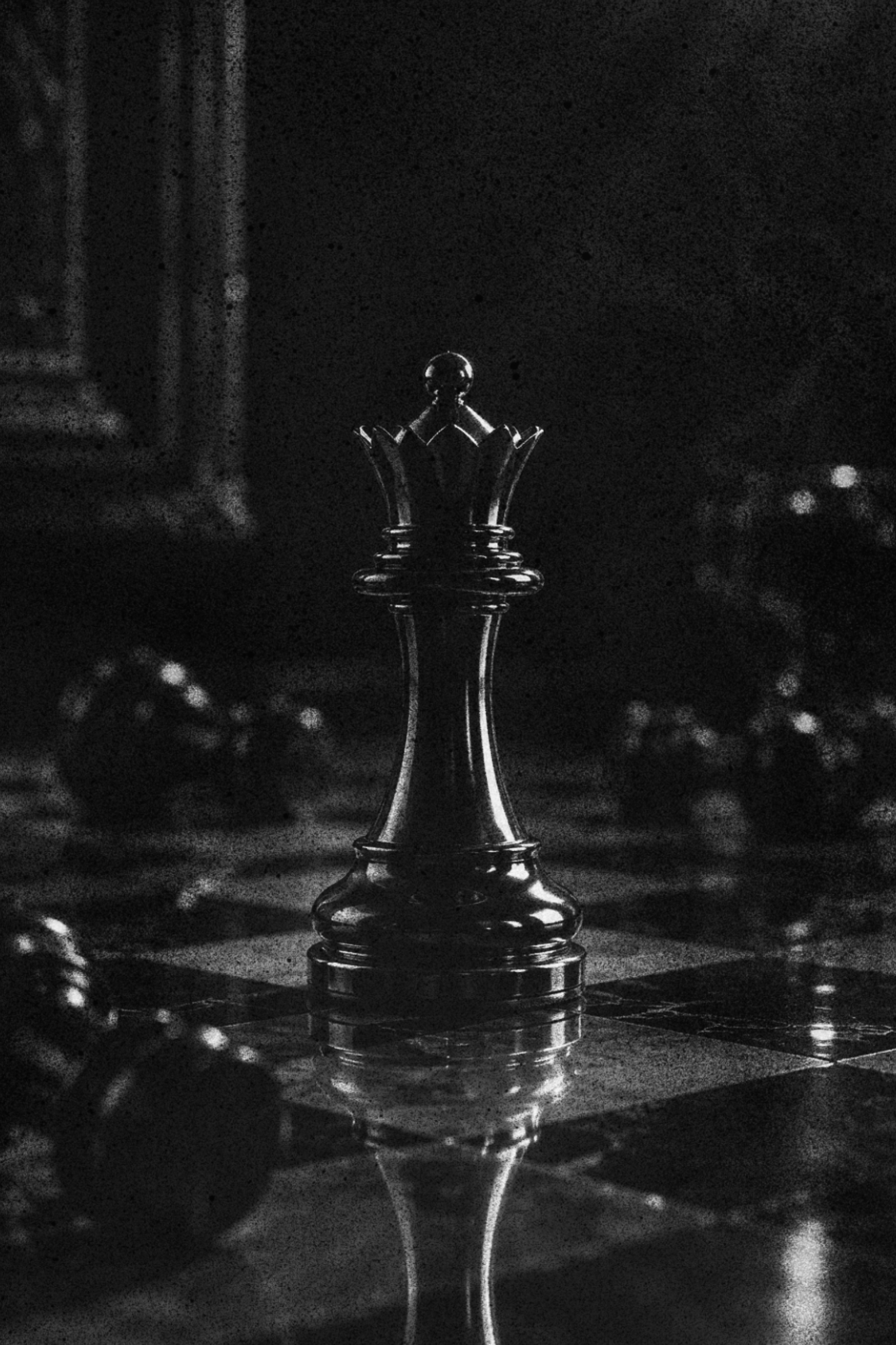 A black-and-white photo of a chessking on a chessboard, with a blurred background of other chess pieces.