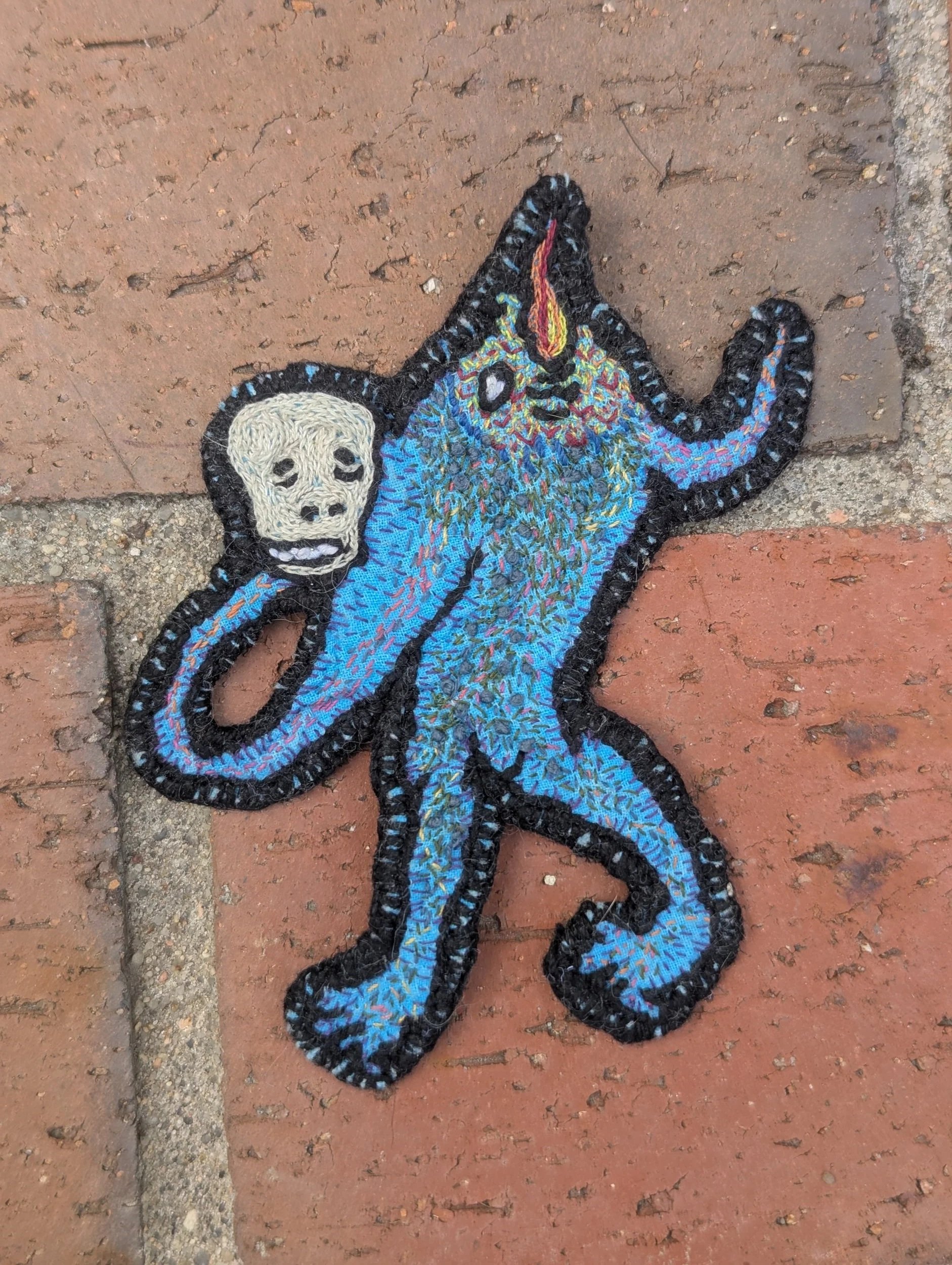 Thread painted embroidery patch of a medieval grotesque