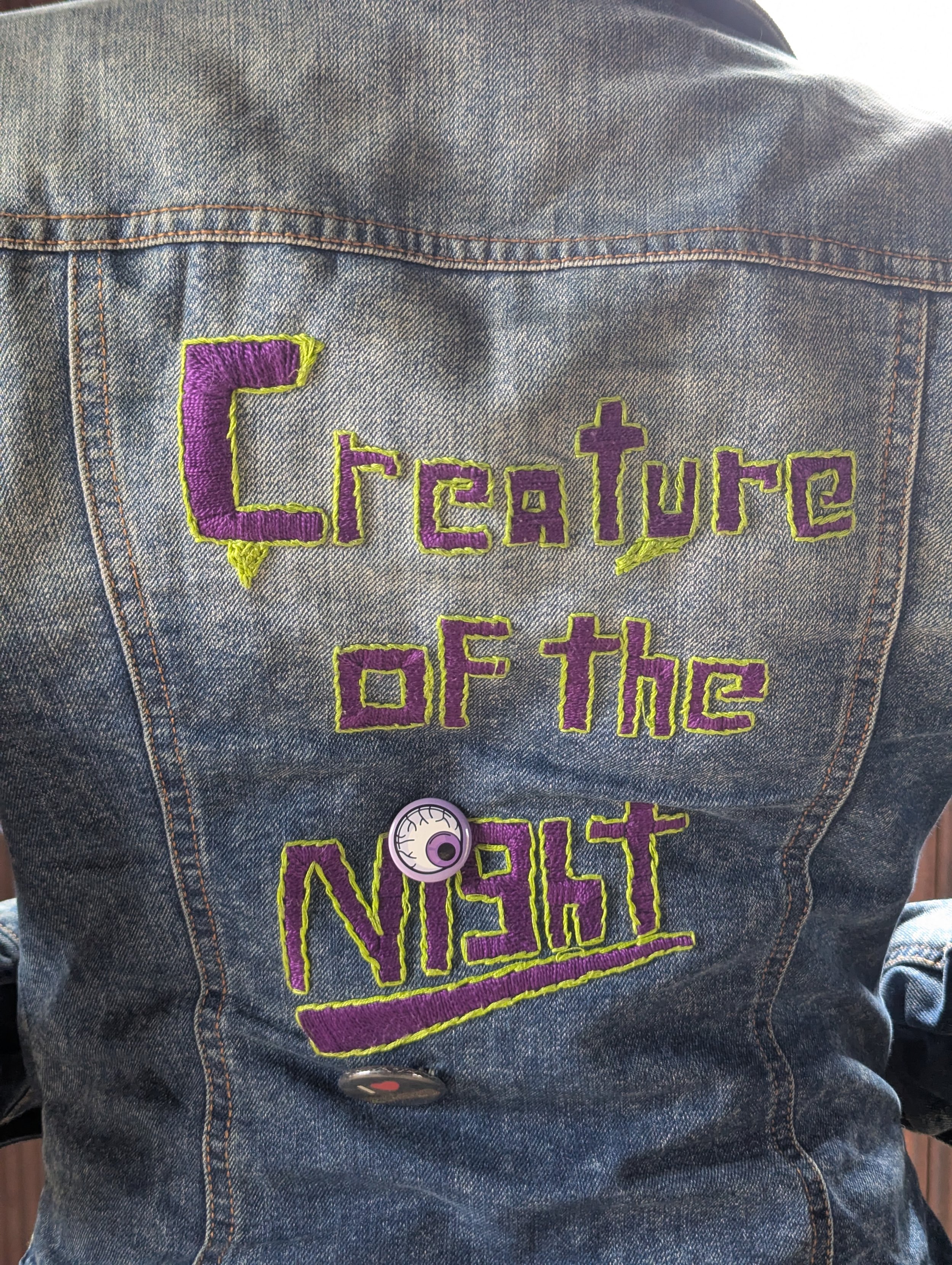 Hand embroidered "Creature of the Night' on the back of a jean jacket
